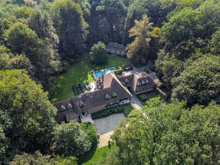 <p><span>Deze klassieke villa is gelegen op een AAA-locatie aan de Bellevuedreef te Schilde, nabij het park.</span></p><p><span>De omheinde tuin van ca. 1,4 Hectare biedt u alle rust en privacy. </span></p><p><span> </span></p><p><span>Indeling</span></p><p><span>U betreedt de villa middels de centrale inkomhal met vestiaire en gastentoilet alsook de trap naar de verdieping. Vanuit de inkomhal toegang tot de ruime leefruimte bestaande uit een zitkamer, een eetkamergedeelte met aansluitend een studeerkamer alsook vanuit de eetkamer toegang tot de ruime leefkeuken. Tevens vanuit de inkomhal toegang tot een ruim bureel met prachtige ingemaakte kasten. De leefkeuken bestaat uit een ontbijtkamer met grote schuiframen naar tuin en terras en een werkgedeelte met eiland en is voorzien van diverse inbouwtoestellen waaronder een Amerikaanse ijskast, combioven en stoomoven, etc. Vanuit de keuken een tweede doorgang naar de eetkamer via een berging en doorgang naar de bijkeuken met zij-inkom. </span></p><p><span> </span></p><p><span>Verdieping</span></p><p><span>De nachthal geeft toegang tot een ruime slaapkamer met eigen badkamer, een logeerkamer met eveneens een eigen badkamer, derde ruime kinderkamer met opnieuw een eigen badkamer. De mastersuite omvat een ruime slaapkamer, dressingkamer en een luxe badkamer. Vanuit de mastersuite doorgang naar de tussengang en diensttrap naar conciërgegedeelte. </span></p><p><span> </span></p><p><span>Garage</span></p><p><span>Inpandige garage voor drie wagens voorzien van automatische poorten. </span></p><p><span> </span></p><p><span>Conciërgewoning</span></p><p><span>Boven de garage bevindt zich een conciërgewoning welke bestaat uit een polyvalente ruimte, slaapkamer en badkamer. </span></p><p><span> </span></p><p><span>Kelder</span></p><p><span>U bereikt de kelder middels een draaiende trap uit natuursteen, de kelder biedt bergruimte, technische ruimte voor CV en zwembad alsook een fraaie wijnkelder. </span></p><p><span> </span></p><p><span>Poolhouse</span></p><p><span>Het grote bijgebouw werd gebouwd in dezelfde materialen als de villa en biedt een volwaardig gastenverblijf met woonkamer, keuken, slaapkamer en badkamer. </span></p><p><span> </span></p><p><span>Bijzonderheden </span></p><p><span>De villa werd gebouwd in 1978 en in 1996 vond een uitgebreide renovatie plaats met vervolgens regelmatige onderhouds- en opfrissingswerken. Er is een verwarmd zwembad aanwezig, ruime terrassen, aangelegde en omheinde tuin met tuinverlichting. De woning is zeer goed beveiligd en voorzien van alarm, camerabewaking etc.</span></p><p><span> </span></p><p><span>Meer inlichtingen via ons kantoor.</span></p>