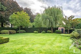 <p><span>Exclusieve villa met loods, prachtige tuin en topafwerking op ruim 7.400 m²</span><span> </span></p><p><span>In een rustige en groene omgeving presenteren wij u deze uitzonderlijke eigendom, gebouwd in 2002, die uitblinkt door haar royale oppervlakte, hoogwaardige afwerking en veelzijdige mogelijkheden. Met een grondoppervlakte van maar liefst 7.414 m² en een combinatie van wooncomfort, werkruimte en ontspanning, biedt dit pand een unieke kans voor wie op zoek is naar een exclusief en veelzijdig geheel.</span></p><p><span>Bij aankomst valt meteen de prachtig onderhouden tuin op, voorzien van een professioneel drainagesysteem en zo ontworpen dat ze de hele dag zonlicht opvangt. Het ruime terras nodigt uit om in alle rust en privacy te genieten van het buitenleven.</span></p><p><span>De woning zelf straalt kwaliteit en ruimte uit. De inkomhal verwelkomt u met een stijlvolle tegelvloer en ingemaakte kasten, en beschikt over een apart gastentoilet met wastafel. De leefruimte is bijzonder royaal en baadt in natuurlijk licht dankzij de vele ramen. Aansluitend vindt u een gezellige tv-kamer die voorzien is van een geïntegreerd muzieksysteem. Vanuit de woonkamer hebt u toegang tot een elegante oranjerie die dienstdoet als veranda, een heerlijke ruimte waar u het hele jaar door kan genieten van het tuinzicht.</span></p><p><span>De volledig uitgeruste keuken vormt een absolute blikvanger voor wie houdt van comfort en functionaliteit. Ze is ingericht met een moderne inductiekookplaat, een vaatwasser, oven en microgolf, een ruime koelkast, dubbele wastafel en een praktische apotheekkast. Alles is tot in de puntjes afgewerkt met oog voor kwaliteit en gebruiksgemak. Aansluitend vindt u een handige berging/wasplaats, die rechtstreeks toegang geeft tot de ruime inpandige garage. Boven de garage bevindt zich een ruime kamer/studio, uitgerust met toilet, wastafel en koelkast, ideaal voor gasten, een nanny of een zelfstandige activiteit.</span></p><p><span>De woning biedt nog meer verrassingen: onder de garage bevindt zich een indrukwekkende mancave, compleet uitgerust met bar, open haard en ruimte voor wijnopslag. Deze plek ademt gezelligheid en is de ultieme ruimte om vrienden en familie te ontvangen.</span></p><p><span>Op de eerste verdieping treft u drie bijzonder ruime slaapkamers. De master-bedroom beschikt over een eigen volledig uitgeruste badkamer en een aparte dressing, terwijl de overige slaapkamers gebruik kunnen maken van een douchekamer en een apart toilet. Op de tweede verdieping bevinden zich nog twee slaapkamers, een aparte badkamer en eveneens een apart toilet. Bovendien is er nog een bergzolder voor extra opslagruimte.</span></p><p><span>Qua comfort is deze woning tot in de puntjes doordacht. De verwarming gebeurt via vloerverwarming op het gelijkvloers, aangevuld met kachels en radiatoren, en bovendien is in de hele woning airconditioning voorzien. Er is een centraal muzieksysteem aanwezig. De spouwmuren zijn volledig geïsoleerd, en de woning beschikt verder over een alarmsysteem met camera's, buitenverlichting en een geïntegreerd waterzuiveringssysteem.</span></p><p><span>Verder bevindt zich naast de woning een grote loods met kantoorruimte van circa 300 m². Deze kan zowel voor professionele doeleinden als voor extra opslag dienen.</span></p><p><span>Deze eigendom combineert luxe, comfort en functionaliteit op een unieke locatie. Een zeldzame kans voor wie wonen en werken wil samenbrengen in een prachtig kader. </span></p><p><span> </span></p><p><span>Plan je graag een bezoek? 0492/39.16.32 (Jelle) |  info@immomk.be - ook voor een correcte waardebepaling kan u bij ons terecht.</span><span> </span></p>