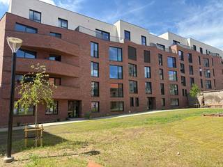 Ben je op zoek naar een nieuw plekje in het bruisende centrum van Leuven? Dit moderne nieuwbouwappartement biedt de perfecte balans tussen rust en de levendige stadsomgeving, en is bovendien onmiddellijk beschikbaar!<br /><br />Gelegen in het nieuwe, duurzame woonproject Burenberg, biedt deze sfeervolle locatie een eigentijdse woonomgeving midden in de stad met een goede verbinding met de autosnelweg of openbaar vervoer.<br /><br />Het <strong>gelijkvloerse appartement </strong>omvat een inkomhal met apart toilet en twee slaapkamers. De leefruimte bevat een volledig uitgeruste open keuken met Siemens toestellen en veel praktische opbergruimte.<br />Het overdekte terras van 10 m² vormt een mooie extra troef waar u het ganse jaar van kan genieten. De badkamer met regendouche, toilet en lavabomeubel met LED-spiegel. Verder is er nog technische opbergruimte met aansluitingen voor een wasmachine en droogkast. Het appartement wordt uitgerust met gordijnen en lichtarmaturen.<br />In de <strong>ondergrondse verdieping</strong> beschikt het appartement bovendien over een kelderberging, één privatieve autostaanplaats met laadpaal en 2 privatieve fietsenstaanplaatsen.<br /><br />Het appartement wordt uitgerust met gordijnen en lichtarmaturen.<br /><br />Dankzij de bijna energie-neutrale afwerking geniet je hier van een hoog wooncomfort. Het appartement wordt verwarmd door vloerverwarming via een geothermisch net en een ventilatiesysteem C+.<br />De vloerverwarming kan passief koelen en voor de zeer warme dagen beschikt u over een design-airco element in de leefruimte. Het EPC-certificaat is nog onderweg maar een zeer degelijke A-score is gegarandeerd!<br />Kortom, een comfortabel, modern en energiezuinig appartement dat vanaf 15 juli beschikbaar is voor bewoning!<br /><br />De huurprijs bedraagt €1500 per maand, met € 100 provisie per maand voor het onderhoud en verbruik van de gemeenschappelijke delen. Nutsvoorzieningen zijn apart af te sluiten.<br /><br /><br />Lijkt dit ruime, moderne en uitstekend gelegen 2-slaapkamerappartement echt iets voor jou? Wees er dan snel bij en maak zelf een afspraak via onze online agenda onder 'bezoekmoment kiezen. Of neem gerust contact met ons op voor verdere informatie of om een bezichtiging te regelen, via telefoon op 016 23 90 81 (elke weekdag bereikbaar tussen 10u en 13u). Dit is een geweldige kans die u niet wilt missen!