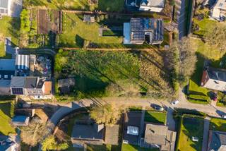 Het betreft een ZW georiënteerd perceel bouwgrond met een breedte van 25,60 m, bestemd voor de oprichting van een vrijstaande eengezinswoning met maximaal twee bouwlagen.
De bouwzone voor het hoofdgebouw situeert zich op minimaal 12 meter van de wegas van de Stijn Streuvelslaan, met een maximale bouwdiepte van 17 meter. De linkergevel van zowel het hoofdgebouw als eventuele bijgebouwen dient zich op minstens 6 meter van de geplande rooilijn van de Rodenbachlaan te bevinden. Aan de rechterzijde geldt een minimale afstand van 3 meter tot de perceelgrens.
Voor bijgebouwen is een aparte zone voorzien, beginnend op 10 meter achter de bouwstrook voor het hoofdgebouw en doorlopend tot op 3 meter van de achterste perceelgrens. Deze bijgebouwen dienen opgericht te worden binnen een maximale diepte van 50 meter gemeten vanaf de rooilijn van de Stijn Streuvelslaan, met een maximale gezamenlijke oppervlakte van 75 m².
Wonen in Zoersel is wonen in het groen, met een vlotte verbinding naar de snelwegen E34 en E313. In het hart van de gemeente ligt het 400 hectare grote Zoerselbos, een prachtig natuurgebied waar u volop kan wandelen en fietsen. 
Vanuit uw nieuwe thuis bereikt u met de fiets in slechts 4 minuten het centrum van Sint-Antonius, met supermarkten, horeca, winkels en speciaalzaken. En ook het openbaar vervoer is er vlot bereikbaar. 
Voor meer informatie of een gratis waardebepaling van uw vastgoed kan u een aanvraag invullen op onze website of even bellen op het nr. 03/345.88.99.