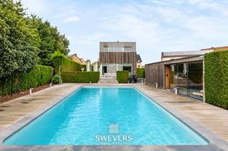 Voor meer info en foto’s, surf naar www.swevers.be – Vrijstaand wonen met 258 m² bewoonbare oppervlakte, een zuidgerichte tuin en volop ruimte voor ontspanning. Deze instapklare open bebouwing aan de Heesstraat 67/A in Bilzen-Hoeselt werd gebouwd in 2002 en doorheen de jaren zorgvuldig vernieuwd. Op het gelijkvloers vindt u een ruime, in 2020 gerenoveerde keuken met eetkamer van 52,36 m², een aparte living van 19,60 m², bureau, berging en toilet. Parket en airconditioning verhogen het wooncomfort. De eerste verdieping telt drie ruime slaapkamers van 21,63 m², 14,78 m² en 14,58 m². De master bedroom werd in 2023 vernieuwd en beschikt over airconditioning en een dressing. Twee slaapkamers zijn uitgerust met maatkasten. Met twee badkamers en drie toiletten is de woning bovendien praktisch ingericht voor een gezin. Extra troeven zijn de inpandige garage van 28,86 m² met elektrische poort, zonnepanelen en een bijzonder ruime kelder van 105,09 m². Verwarming gebeurt op stookolie via radiatoren en vloerverwarming. Buiten wacht een volledig omheind perceel van 7a 70ca met een mooi aangelegde, zuidgerichte tuin. Het zwembad, de jacuzzi en het vernieuwde poolhouse van 20 m² met plafondverwarming en tv-aansluiting zorgen voor extra ontspanning en privacy. Ook de ligging is praktisch, met een bushalte op 100 meter, scholen op 300 meter en kinderopvang op 500 meter. Maastricht en Alden Biesen liggen op circa 8 km. Voor meer informatie, bel 012 699 900. Bron bewoonbare oppervlakte: EPC – verslag.