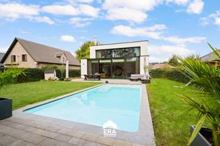 [[ DIT PAND NEEMT DEEL AAN DE ERA OPEN HUIZEN DAG OP 6/12 VAN 11:00 TOT 12:00 ]]
<p><strong>Stijlvol wonen aan de rand van het bos – luxueuze villa in Grimbergen</strong></p><p>In een rustige, doodlopende straat van het groene Grimbergen bevindt zich deze exclusieve, energiezuinige villa die luxe en comfort op een uitzonderlijk niveau samenbrengt. Achter de strakke architectuur schuilt een warm en hedendaags interieur, met een fenomenaal zicht op de zuidgerichte tuin en het achterliggende bos – pure privacy en sereniteit, recht vanuit uw leefruimte.</p><p>Dankzij een geothermische warmtepomp, vloerverwarming, 13,5 kW zonnepanelen, een 20 kW thuisbatterij én EPC-label A, woont u hier toekomstgericht en duurzaam, zonder in te boeten op comfort. De woning telt vier ruime slaapkamers, waarvan de master suite is uitgerust met een royale inloopdressing en een en-suite badkamer.</p><p>De kelder (150m³) biedt veel stockageruimte en is voor 60m² ingericht als homecinema en speelruimte. Dit biedt een zee aan mogelijkheden – van wellness tot werkruimte,... Buiten geniet u van een verwarmd zwembad, perfect geïntegreerd in het landschap. Voor uw veiligheid is er videobewaking en een alarmsysteem.</p><p>De dubbele garage en royale oprit maken het plaatje compleet. Dit is geen huis, maar een levensstijl – discreet luxueus, doordacht ontworpen en tot in de puntjes afgewerkt.</p>