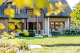 <p>Deze prachtige villa uit 2000 combineert hoogwaardig materiaalgebruik, een doordachte architectuur en een uitstekende staat van onderhoud. De woning bevindt zich op een mooi breed perceel met bossen aan de achterzijde, wat zorgt voor rust, privacy en een groen uitzicht. Binnen geniet u van bijzonder ruime leef- en slaapruimtes, ideaal voor gezinnen of wie graag royaal woont. De indrukwekkende woonkamer met open haard, de grote keuken en de dubbele inpandige garage met ruime oprit versterken het comfortabele karakter van deze woning. Dankzij de residentiële ligging in een groene omgeving woont u hier rustig met een vlotte verbinding naar het centrum van Lokeren.</p>
<p>Belangrijkste ruimtes:</p>
<p>• Imposante inkomhal (14 m²) voorzien van prachtig raamwerk en vestiaire</p>
<p>• Ruime woonkamer (70 m²) met open haard, veel lichtinval en prachtig zicht op groen</p>
<p>• Grote keuken (24 m²)</p>
<p>• Bureel (17 m²), ideaal voor thuiswerk of vrij beroep (2 toegangen)</p>
<p>• Wasplaats (10 m²)</p>
<p>• Dubbele inpandige garage (40 m²) met automatische garagepoort</p>
<p>• Slaapkamer (26 m²)</p>
<p>• Slaapkamer (17 m²)</p>
<p>• Dressing (4 m²)</p>
<p>• Badkamer (25 m²) met ligbad en dubbele wastafel in meubel</p>
<p>• Badkamer (8 m²) met inloopdouche en wastafel in meubel</p>
<p>• Ruime nachthal (28 m²)</p>
<p>Troeven:</p>
<p>• Architecturale villa met hoogwaardige afwerking en perfect onderhoud</p>
<p>• Breed perceel met bossen aan de achterkant en veel privacy</p>
<p>• Zeer ruime leefruimtes, grote slaapkamers en dubbele inpandige garage</p>
<p>Neem vandaag nog contact op met je ERA-makelaar voor een bezoek. JOUW DROOMHUIS. ZO GEVONDEN!</p>