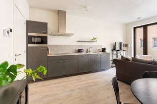 This recently built flat of approx. 58 m² is situated in the stunning ‘De Dams’ development on Lange Nieuwstraat. The combination of historic buildings and modern contemporary architecture makes this project a unique residential concept in the city centre.<br /><br />Through the entrance hall, which has space for a coat rack, you have direct access to the pleasantly spacious living area overlooking the cosy indoor terrace of approx. 4 m². The open-plan kitchen is finished to the highest standard and features a sleek, modern design with handle-less cupboards. It is fitted with neatly integrated appliances.<br /><br />The bedroom is pleasantly spacious and shares the adjacent bathroom, which features a shower, a vanity unit with a double washbasin and a toilet. There is a utility room with connections for a washing machine and tumble dryer.<br /><br />The residence was built to the BEN (Nearly Energy-Neutral) standard, giving this flat an E-level of just E25. Sustainable living in an extremely central yet quiet location is therefore a key feature here.<br />A nice extra is the innovative ‘Bringme Box’ system. This means that everything relating to opening the door, communication, and the sending and returning of parcels is digitised.<br /><br />Communal bicycle storage available.<br /><br />Service charges: 65 euros per month.<br />All utilities (gas, water and electricity) are to be met privately by the tenant.<br /><br />Available from 1 July 2026.