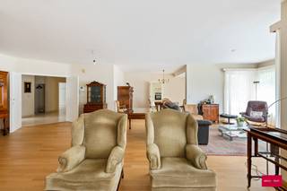 Dit uitzonderlijk appartement van maar liefst 204 m² combineert een zee van ruimte met een overvloed aan natuurlijk licht. Gelegen op de eerste verdieping van een verzorgd gebouw, geniet u hier van een stijlvolle en comfortabele thuis waar elk detail bijdraagt aan een gevoel van rust en openheid.

Bij het betreden van de ruime inkomhal ervaart u meteen de aangename, lichte sfeer. De natuurstenen vloer en de royale indeling geven een voorproef van de elegantie die de rest van het appartement te bieden heeft.

Leefruimte vol daglicht
De leefruimte is zonder twijfel het kloppend hart van dit appartement. Dankzij de grote raampartijen rondom baadt de ruimte de hele dag in zonlicht. De parketvloer en vloerverwarming zorgen voor een warme, huiselijke toets. Hier vloeien woon- en eetgedeelte naadloos samen tot een riant geheel, perfect om gasten te ontvangen of om zelf in alle rust te genieten.

Keuken en praktische ruimtes
De keuken is volledig uitgerust en aangrenzend bevinden zich een praktische ruime (koele)berging alsook een wasplaats en technische ruimte.

Drie slaapkamers
Het appartement beschikt over drie ruime slaapkamers. De master bedroom is voorzien van een en-suite badkamer, terwijl de overige kamers gebruik kunnen maken van een tweede badkamer. Tenslotte is er ook een apart gastentoilet aanwezig.

Buitenruimte &amp; voorzieningen
Het zonnige terras vormt een heerlijke plek om buiten te ontspannen met een groen uitzicht. Daarbovenop beschikt u over een dubbele garagebox (verplicht bij aan te kopen aan €30.000) en is er een lift in het gebouw aanwezig.

Ligging
De ligging is ideaal: net buiten de Ring van Turnhout, met groene wandelmogelijkheden letterlijk om de hoek. Winkels, horeca en alle nodige voorzieningen bereikt u eenvoudig met de fiets.

Maandelijkse kosten
De gemeenschappelijke kosten bedragen ca. €300/maand. Volgende zaken zijn hierbij inbegrepen: privéwaterverbruik, poetsen van de gemene delen, ramenwasser, tuinonderhoud, lift, ...