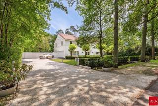 <p>Zoekt u het ultieme vakantiegevoel zonder uw huis te verlaten? Dan is deze villa de perfecte woning voor u. Deze luxe, moderne en zeer lichte villa bevindt zich in de groene, residentiële Bellemond wijk op een toplocatie te ’s Gravenwezel. Hier geniet u van volledige privacy in een prachtige zuidwest-georiënteerde tuin met een verwarmd zwembad. De villa is ideaal gelegen nabij scholen, openbaar vervoer en winkels, en ligt in een van de meest prestigieuze wijken van ’s Gravenwezel.</p>
<p>Deze architectenwoning, ontworpen door de gerenommeerde architect John Bontinck, is gebouwd met hoogwaardige materialen. De visie van de architect om de tuin sterk bij de woning te betrekken, is werkelijk verbluffend geslaagd. Bij binnenkomst wordt u meteen gecharmeerd door het vakantiegevoel dat de villa uitstraalt. Een prachtige doorkijk naar de tuin en het zwembad verwelkomt u direct.<br /><br />INDELING<br /><br /><strong>Gelijkvloers:<br /></strong>Bij binnenkomst wordt u meteen gecharmeerd door het vakantiegevoel dat de villa uitstraalt. Een prachtige doorkijk naar de tuin en het zwembad verwelkomt u direct. <br />U treedt de villa binnen via een inkomhal met een apart gastentoilet en een ruime vestiaire. Een dubbele glazen deur biedt toegang tot de riante en lichte woonkamer met een doorlopend raam tot de verdieping. De leefruimte, verdeeld in zithoek, salon en eetkamer, is voorzien van een eiken parketvloer en een prachtig open haard. De ruimtes vloeien mooi in elkaar over en zijn in direct contact via grote deurramen met het zuidwest-georiënteerde terras, de tuin en het zwembad.<br /><br />Aansluitend aan de leefruimte vindt u de volledig geïnstalleerde keuken met een kookeiland, ontbijthoek, tal van opbergkasten en moderne toestellen, waaronder een Amerikaanse koelkast. Door kamerhoge raampartijen rondom de keuken wordt deze ruimte overspoeld met natuurlijk licht en biedt het een prachtig uitzicht op de tuin en het zwembad.<br /><br />Een praktische douchekamer met toegang naar buiten is ideaal na een zwembeurt in het zwembad.<br /><br />Een mooie houten trap leidt naar de eerste verdieping, waar een impressionante vide extra licht en uitzicht biedt vanuit de verdieping op de prachtige tuin.<br /><br /><strong>1e Verdieping:<br /></strong>Op de 1e verdieping vindt u de mastersuite met dressing en badkamer – met ligbad, dubbele lavabo en toilet. De 2e slaapkamer (ca. 31m²) op parket met ingemaakte kasten geeft uit op een prachtig terras. De 2e (ca. 20m²) en 4e slaapkamers (ca. 18m²) delen de 2e badkamer met ligbad, lavabo en toilet. Verder is er nog een handige berging, ideaal voor een linnenkast of een extra douchekamer.<br /><br /><strong>Tuin en Zwembad<br /></strong>Geniet volop van de zonnige tuin in volledige privacy zonder enige inkijk. De tuin is aangelegd met verschillende terrassen, een verwarmd zwembad en een tuinhuis. Deze buitenruimte biedt de perfecte setting voor ontspanning, zomerse barbecues en gezellige avonden.<br /><br />Een inpandige garage biedt ruimte voor 2 wagens en heeft een automatische toegangspoort. Daarnaast is er een ruime oprit met plaats voor meerdere wagens, wat extra gemak en parkeerruimte biedt voor u en uw gasten.<br /><br />Kortom, deze villa is een waar paradijs voor wie houdt van een luxe levensstijl met een vleugje vakantie. De ruime indeling en grote ramen zorgen voor een lichte en luchtige sfeer. Mis deze unieke kans niet om in een van de meest gewilde wijken van ’s Gravenwezel te wonen.</p>
<p></p>
<p>BIJZONDERHEDEN:<br />+ Architect John Bontinck<br />+ Nieuw gietvloeren op verschillende ruimtes<br />+ Vloerverwarming <br />+ 15 zonnepanelen (2024)<br />+ Gunstig EPC: 164kWh/m²<br />+ Vloerverwarming op GLV<br />+ Asbestvrij.<br />+ Bose audio-installatie in alle ruimtes, voor optimale geluidservaring.<br /><br />Voor meer informatie of een bezoek aan deze gezellige woning, neem gerust contact op met Sigalit via Sigalit@reds.be of op 0475668474</p>