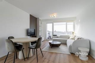 <p><span>Gerenoveerd appartement (77 m²) in Antwerpen met 2 slaapkamers en 2 terrassen met zicht op het Rivierenhof.</span></p><p><span> </span></p><p><span>Recht tegenover het Rivierenhof, bevindt zich op de vijfde verdieping van een verzorgd gebouw dit lichtrijke hoekappartement. Dankzij deze topligging geniet je van een uitstekende bereikbaarheid met tram, bus, velo en wagen, terwijl het uitgestrekte groen van het Rivierenhof letterlijk aan je overkant ligt. Met de toekomstige overkapping van de Ring gaat het een naadloze overgang worden naar een nog groenere omgeving.</span></p><p><span> </span></p><p><span>Het appartement maakt deel uit van een verzorgd en goed onderhouden gebouw waarvan het dak conform geïsoleerd werd. Dit hoekappartement werd in 2023 volledig en met bijzonder veel oog voor detail gerenoveerd, waarbij gekozen werd voor kwalitatieve en duurzame materialen. Dankzij de talrijke ingemaakte kasten werd de beschikbare ruimte optimaal benut, wat zorgt voor een strak en functioneel geheel. De elektriciteit is conform, de ramen zijn voorzien van dubbele beglazing en met een gunstige EPC-score B ben je verzekerd van energiezuinig wooncomfort.</span></p><p><span> </span></p><p><span>Een hoekappartement betekent maximale lichtinval én twee terrassen. Je beschikt over een oost-georiënteerd terras van 4 m² en een ruim zuid-terras van 11 m², met zicht op het Rivierenhof. Binnenkomen doe je in de inkomhal met ingemaakte vestiairekast, waarbij aansluiting voorzien werd voor een wasmachine. De eerste slaapkamer (13 m²) biedt een comfortabele oppervlakte en bevindt zich tegenover de moderne badkamer (5 m²), uitgerust met een lavabomeubel en inloopdouche. Het toilet is apart voorzien. De tweede slaapkamer (7 m²) is perfect inzetbaar als dressing, bureau of kinderkamer — een flexibele ruimte die je naar eigen noden kan invullen. De lichtrijke leefruimte (29 m²) vormt het hart van het appartement. Hier is de op maat gemaakte keuken in donker houtfineer een echte eyecatcher. Ze combineert een stijlvolle uitstraling met hedendaags comfort en maakt koken en tafelen tot een plezierige ervaring. Tot slot is er achteraan het gebouw een gratis bewonersparking waar je gebruik van kan maken en een gemeenschappelijke fietsenstalling beschikbaar.</span></p><p><span>Ben je op zoek naar een instapklaar appartement? Mis deze kans niet! Bewoonbare opp. 77 m² ref.: bruto vloeropp. Voor meer info of een gratis schatting surf naar </span><span><span>www.hansimmo.be</span></span></p><p><span> </span></p>
