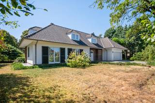 <p>Karaktervolle villa met 4 slaapkamers op uitzonderlijk perceel van 2.475 m².</p>
<p>Ruimte, privacy en een groene omgeving komen hier op een bijzonder aangename manier samen. Deze ruime villa is gelegen op een royaal perceel van maar liefst 2.475 m² en biedt dankzij de volledig groen omzoomde tuin een uitzonderlijke mate van privacy.</p>
<p>De woning beschikt over een aangename leefindeling met vier ruime slaapkamers, een inpandige garage, bureauruimte en een ruime tuin en vormt daarmee een ideale basis voor wie op zoek is naar een ruime gezinswoning met potentieel.</p>
<p><span>Gelijkvloers</span></p>
<p>U wordt verwelkomd in een ruime inkomhal die meteen toegang biedt tot verschillende leefruimtes. Aan de linkerzijde bevindt zich de royale woonkamer, waar een open haard, gezellige eethoek en parketvloer zorgen voor een warme en sfeervolle uitstraling.</p>
<p>De keuken bevindt zich aan de achterzijde van de woning en geniet van een aangenaam zicht op de tuin. Een aparte inkom achteraan zorgt bovendien voor een praktische verbinding met de keuken en woonkamer.</p>
<p>Aansluitend aan de keuken bevindt zich een ruime bergruimte met de nodige aansluitingen voor wasmachine en droogkast.</p>
<p>Aan de rechterzijde van de inkomhal leidt een aparte hal naar de bureauruimte, een afzonderlijk toilet en de inpandige garage met sectionale poort. Vanuit de keuken is tevens de kelder bereikbaar.</p>
<p><span>Eerste verdieping</span></p>
<p>Via de karaktervolle ronde draaitrap bereikt u de eerste verdieping. De nachthal, uitgerust met praktische kasten, geeft toegang tot maar liefst vier ruime slaapkamers en de badkamer. De badkamer is ingericht met een ligbad, dubbele lavabo en toilet.<br /><span><span></span></span></p>
<p>Een van de absolute troeven van deze eigendom is het royale perceel van 2.475 m². De tuin is rondom volledig groen aangelegd, waardoor de woning heerlijk verscholen ligt en u in alle rust kunt genieten van uw buitenomgeving.</p>
<p>Extra info:<span> gunstig gelegen I EPC</span><span> 928 kWh/(m²jaar) label F</span><span> I </span><span>infoplicht: Vg, Wg, Vv, Gvkr, Gmo I watertoets: P-score: A I G-score: A.<br /><br />Renovatieverplichting residentiële gebouwen van toepassing (label F). Meer info: https://www.vlaanderen.be/een-woning-kopen/renovatieverplichting-voor-residentiele-gebouwen.<br /></span></p>