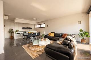 <p><span>Veel ruimte, daglicht en een strakke, hedendaagse afwerking: dit bijzondere appartement combineert een royale woonverdieping met 2 slaapkamers, dressing én heel wat ruimte. De grote open keuken, badkamer XL en het zuidgerichte terras maken het plaatje compleet. Nabij het Te Boelaarpark en Rivierenhof zit je hier ook qua locatie helemaal goed. Dubbele garage van ca. 44,5 m² is bij te huren (€300,00 per maand).</span></p><p><span> </span></p><p><span>Wonen in het licht</span></p><p><span>De woonruimte bevindt zich op de eerste verdieping. Je komt binnen in de hal op een strakke tegelvloer, die meteen de toon zet voor de rest van het appartement. Vooraan ligt de grote open leefruimte, waar keuken, eetkamer en salon mooi in elkaar overvloeien. Grote raampartijen trekken hier volop daglicht naar binnen en geven het geheel een bijzonder ruim gevoel. De witte keuken met granieten werkblad is strak, minimalistisch én uitgebreid uitgerust. Je hebt er een groot kookeiland met inductieplaat en geïntegreerde Novy-dampkap, vaatwasser, stoomoven, microgolfoven en gewone oven. De hoge kastenwand zorgt voor massa's bergruimte en er is zelfs een aparte grote diepvries voorzien. Een keuken voor wie graag kookt – en evengoed voor gasten die gezellig aanschuiven aan het eiland. Vanuit de leefruimte stap je het royale terras op: maar liefst ca. 24m² groot, over vrijwel de volledige breedte van het appartement en zuidgericht. Een fijne extra buitenruimte om van de zon te genieten.</span></p><p><span> </span></p><p><span>2 slaapkamers, royale dressing & badkamer XL</span></p><p><span>Een glazen pivotdeur scheidt het woon- van het slaapgedeelte. Hier vindt je twee volwaardige slaapkamers en een royale dressing volledig ingericht met maatkasten. Ook de badkamer mag gerust XL genoemd worden: zo’n ca.13m², volledig betegeld en dankzij de grote dakkoepel verrassend licht. Je hebt er een hoekbad, ruime walk-in douche, dubbele lavabo met groot meubel en spiegelkast, handdoekradiator en bidet. Verder zijn er op deze verdieping een apart gastentoilet en een technische ruimte met aansluiting voor wasmachine en droogkast en de Cv-installatie. </span></p><p><span>Op het gelijkvloers vind je nog een bureauruimte met wandmeubel kast, handig voor thuiswerk, met daarnaast een apart, volledig betegeld toilet met handenwasser. Op de tussenverdieping vind je extra bergruimten met een oppervlakte van circa 32m².</span></p><p><span> </span></p><p><span>Groen wonen met alles vlakbij</span></p><p><span>Je woont hier in de buurt van het Rivierenhof en Te Boelaarpark, op de grens van Borgerhout en Deurne. Het park combineert ruime grasvelden en bos met wandelpaden, een speeltuin, speelfontein en ruimte om te sporten. Ook het Boekenbergpark ligt in de buurt, met onder meer zijn bekende ecologische zwemvijver en verschillende sportmogelijkheden. </span></p><p><span>Dat vele groen combineer je hier met de voordelen van de stad: winkels, scholen en openbaar vervoer zijn in de omgeving aanwezig en de Ring en Singel zorgen voor een vlotte verbinding. Zo krijg je een bijzonder praktische uitvalsbasis voor wie graag ruim woont, zonder het groen te moeten missen.</span></p><p><span> </span></p>