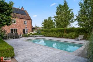 Welkom aan de Lage Dreef 29 in Heist-op-den-Berg!<br />Deze prachtige, instapklare open bebouwing biedt je alle comfort en luxe die je je maar kan wensen. Gelegen in een rustige buurt, geniet je hier van een uitstekende ligging en een fijne woonomgeving. De woning biedt een indrukwekkende bewoonbare oppervlakte van maar liefst 389 m², waardoor je zowel binnen als buiten geniet van een enorme oppervlakte.<br /><br />Wat deze woning uniek maakt, is de energiezuinigheid. Met een uitstekend EPC-label A (96 kWh/m² jaar) ben je helemaal klaar voor de toekomst! Je profiteert hier van maar liefst 36 zonnepanelen, 3 thuisbatterijen, een zonneboiler, een laadpaal en airco in een aantal ruimtes. Hierdoor geniet je niet alleen van een heerlijk binnenklimaat, maar hou je ook je energiefactuur bijzonder laag.<br /><br />Buiten is het volop vakantiegevoel in de fraai aangelegde tuin. Ontspan in je eigen verwarmde zwembad met automatische chloor- en pH-regeling, of kom tot rust in het tuinhuis dat is uitgerust met een toffe bar. Er is ook een eigen infraroodsauna.<br /><br />Ook aan de praktische kant is gedacht: je beschikt over een ruime inpandige dubbele garage, liefst drie extra staanplaatsen, een sfeervolle gashaard in de leefruimte en een aangesloten regenwaterput. Bovendien zijn alle rolluiken elektrisch.<br /><br /><u><strong>INDELING:</strong></u><br /><strong>Gelijkvloers:</strong> Inkomhal, toilet, bureelruimte, woonkamer, keuken, wasplaats, dubbele garage, berging<br /><strong>1ste verdieping: </strong>Nachthal, 3 slaapkamers waarvan één met dressing, badkamer, apart toilet.<br /><strong>2de verdieping: </strong>Tussenverdieping met speelkamer.<br /><strong>Zolder: </strong>Zolderkamer en extra bergzolder daarboven.<br /><strong>Tuin:</strong> Tuin met terras, zwembad. Tuinhuis met overdekt terras. Bijgebouw met bar. 3 autostaanplaatsen. Laadpaal<br /><strong>Kelder:</strong> Kruipkelder onder de garage.<br /><br />Ervaar zelf de vele voordelen van deze woning tijdens een persoonlijke rondleiding.<br />Maak vandaag nog je afspraak.<br />Mail naar info@immopersyn.be of bel 013 444 008.<br />