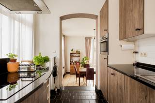 Deze herenwoning grenst aan de site 'Binnenhof' in het centrum van Hingene. Het gebouw is gerenoveerd met oog voor detail en behoud van de oorspronkelijke elementen. Het gebouw is vastgesteld bouwkundig erfgoed: Burgerhuis met bakstenen lijstgevel van vijf traveeën en twee bouwlagen onder pseudomansardedak, met oeils-de-boeuf en centraal dakvenster, vermoedelijk van circa 1912. Hierdoor geniet het gebouw specifieke vrijstellingen op energieprestatieregels. Gelegen recht tegenover de kerk van Hingene en kasteel D'Ursel is dit een ideale locatie voor mensen die van rust en privacy houden maar graag een centrale uitvalsbasis hebben naar N16 en A12. Het gebouw bestaat uit 3 appartementen, één per etage waardoor dit een standingvolle, kleinschalige residentie is. <br /><br />Indeling: Via de inkomhal kom je binnen in de ruime leefruimte (26m²) met terras. Door de zuid orientatie kan u volop genieten van de zon en zijn warmte op het terras. Via de leefruimte kan je naar een aangrenzende kamer (11m²) die gebruikt kan worden als bureau, tv-hoek, leeshoek,... . De keuken is bereikbaar via de leefruimte en beschikt over een kookplaat, oven, ijskast en vaatwasser. Achter de keuken is er een berging met aansluiting voor wasmachine en droogkast. In de inkomhal is er een afzonderlijk gastentoilet en een vestiaire. Via de hal kan je naar het slaapgedeelte. De masterbedroom is met zijn 20m² enorm ruim. Deze slaapkamer heeft een aangrenzende badkamer, met dubbele lavabo en bad. De tweede slaapkamer beschikt tevens over een eigen douche met lavabo en douche. Het volledige appartement beschikt over grote raampartijen wat er voor zorgt dat elke kamer van natuurlijk licht geniet. <br /><br />Mogelijkheid tot het aankopen van een overdekte staanplaats achteraan aan 15.000 euro. <br /><br />Het appartement is momenteel verhuurd waardoor het ook ideaal is als investering. <br /><br />Omgeving: Gesitueerd in een rustige omgeving nabij de kerk van Hingene. N16 en A12 zijn zeer toegankelijk vanaf hier. Openbaar vervoer op wandelafstand.