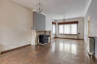 Deze halfopen bebouwing is gelegen vlakbij invalswegen.We betreden de woning via een ruime inkomhal, die toegang biedt tot de living en de open...