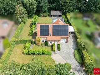 <p>Een charmante, energiezuinige villa met zwembad en indrukwekkend houten poolhouse in het groen van Zoersel</p>
<p>In een rustige, doodlopende straat in Zoersel, verscholen tussen het groen, bevindt zich deze bijzonder charmante woning die uitblinkt in ruimte, licht, comfort en privacy. Dankzij de uitstekende ligging geniet u hier van absolute rust en een groene omgeving, terwijl het centrum, scholen en alle voorzieningen vlot bereikbaar blijven.</p>
<p>Bij het betreden van de woning wordt u meteen omarmd door een warme en uitnodigende sfeer. Een lichte inkomhal met gastentoilet en vestiarekast verwelkomt u in deze charmante woning. De ruime leefruimtes genieten dankzij de grote raampartijen van een overvloed aan natuurlijk licht en staan in directe verbinding met de prachtig aangelegde tuin met zwembad en meerdere terrassen. De combinatie van hoogwaardige materialen, warme accenten en een doordachte indeling zorgt voor een bijzonder aangename woonbeleving.</p>
<p>De woonkamer vormt samen met de eetruimte het hart van de woning en beschikt over een sfeervolle gashaard, die zorgt voor extra warmte en gezelligheid tijdens de koudere maanden. De volledig ingerichte keuken sluit hier harmonieus op aan en biedt alle comfort voor dagelijks gebruik en gezellige momenten met familie en vrienden.</p>
<p>Een elegante houten trap met een prachtige vide leidt u naar de eerste verdieping waar de slaapkamers zich bevinden. De woning beschikt over een ruime mastersuite met een royale dressing en een stijlvolle badkamer, waardoor een echte privé-oase ontstaat. Daarnaast zijn er drie zeer ruime kinderkamers. Eén van deze kamers geniet dankzij de rechtstreekse verbinding met een volledig ingerichte zolderverdieping over een unieke extra ruimte, ingericht als een echte droomstudio voor elk kind. De kinderen beschikken bovendien over een aparte, ruime badkamer, uitgerust met een bad, inloopdouche, lavabo en toilet.</p>
<p>Verder beschikt de woning over een ruime waskamer, een praktische garage voor één wagen en een carport, waardoor ook op praktisch vlak aan alle comfort werd gedacht.</p>
<p>De zonnige, volwassen tuin met zwembad biedt volledige privacy en vormt de ideale setting voor lange zomeravonden, gezellige diners of ontspannen momenten met familie en vrienden.</p>
<p>Een absolute blikvanger van deze eigendom is het indrukwekkende houten poolhouse in de tuin. Dit stijlvolle bijgebouw vormt een volwaardige tweede leefruimte en is uitgerust met een gezellige zitruimte met kachel, een sfeervolle bar, een aparte bureauruimte, een sauna, douche en toilet. Hierdoor biedt het poolhouse een uitzonderlijke flexibiliteit: van ontspannings- en wellnessruimte tot volwaardige werk- of gastensuite. In combinatie met het zwembad, de zonnige terrassen en het omliggende groen ontstaat hier een unieke buitenbeleving met een permanent vakantiegevoel in eigen tuin.</p>
<p>Ook op vlak van energiezuinigheid scoort deze woning uitstekend dankzij de talrijke zonnepanelen, goed voor een gunstig EPC-label B, waardoor hedendaags comfort perfect gecombineerd wordt met duurzaam wonen.</p>
<p><strong>Bijzonderheden</strong></p>
<ul>
<li>Zee van ruimte en uitzonderlijke lichtinval</li>
<li>Prachtig aangelegde tuin met zwembad</li>
<li>Imposant houten poolhouse met wellness- en leeffaciliteiten</li>
<li>Energiezuinig wonen met EPC-label B</li>
<li>Aanzienlijke zonnepaneleninstallatie (PV)</li>
<li>Asbestvrij</li>
</ul>
<p>Kortom: een uitzonderlijk charmante en energiezuinige villa waar ruimte, licht, natuur en luxe buitenbeleving samenkomen. Een unieke thuis voor wie op zoek is naar rust, privacy en een hoogwaardige woonomgeving in het groene Zoersel.<br /><br />Voor meer informatie of bezoek aan deze gezellige woning neem contact met Sigalit via sigalit@reds.be of op 0475668474</p>