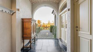 Deze tijdloze villa in landelijke stijl op perceel van 4.615 m² is gelegen aan de rand van het centrum en groengebied te Oud-Turnhout, omgeven door weilanden. Het eigendom omvat een villa, een dubbele carport en bijgebouw van ca. 500 m². Het gehele eigendom is volledig omheind, mooi aangelegd en afgesloten met automatische poort. <br /><br />De villa: <br />Deze stijlvolle villa werd nieuw gebouwd in 1998 en werd afgewerkt met hoogwaardige materialen. Ze heeft een speelse en open indeling en is ingedeeld als volgt: <br /><br />Gelijkvloers: <br />U betreedt de inkomhal van deze villa met grote raampartij met zicht op de achtertuin. Gastentoilet aanwezig. <br />Rechts vanuit de inkomhal betreedt u de leefruimte voorzien van sfeervolle zithoek met houtkachel. De hoge plafonds en grote raampartijen zorgen voor een zeer ruimtelijk gevoel. Praktisch bureau met vast meubilair treft u eveneens in deze leefruimte. De keuken met eethoek bevindt zich aanpalend en is compleet ingericht met Lacanche kookfornuis op gas met oven, warmhoudkast, koelkast en vaatwasser. De zij-inkom biedt toegang tot de keuken, de wasplaats en de handige voorraadberging. <br />Verder op het gelijkvloers , aan de linkerzijde van de inkomhal, treft u het binnenzwembad. Het zwembad wordt verwarmd dmw een warmtepomp en is voorzien van een automatisch roldeck. <br /><br />Verdieping: <br />Vanuit de woonkamer vertrekt de trap naar de bovenverdieping. U komt uit op een open vide die momenteel wordt gebruikt als ontspanningsruimte. De mastersuite bereikt u van hieruit. Deze omvat een masterbedroom met aanpalende dressing en badkamer voorzien van ligbad en dubbele lavabo. Apart toilet aanwezig op de open vide. Twee kinderslaapkamers vindt u aan de andere zijde van de villa, dewelke samen een douchekamer delen. <br />Vaste trap naar de zolderverdieping, waar u nog extra slaapkamer treft. <br />Een tweede trap naar bovenverdieping vertrekt vanuit de zwembadruimte. <br /><br />Carport/garage en stalgebouw: <br />Verder beschikt het eigendom tot over een bijgebouw van ca. 500 m². In 2014 werd het dak van de stal vernieuwd. Deze voormalige landbouwstallen worden momenteel gebruikt als opslagruimte. 2 grote toegangspoorten aanwezig. Aanpalend is een dubbele overdekte carport met kleine zolderruimte aanwezig. <br /><br />Tuin: <br />De tuin met vijverpartij is mooi aangelegd rondom de woning en is bovendien volledig afgesloten. Afgesloten weide aanwezig naast het bijgebouw, ideaal voor het houden van dieren. <br /><br />Bijzonderheden: <br />- bijzonder eigendom met unieke combinatie - wonen / opslag<br />- gunstige locatie nabij het centrum van Oud-Turnhout, omgeven door veel groen en weiland. <br />- verwarming op stookolie , dmv vloerverwarming zowel op gelijkvloers als verdieping<br />- alarminstallatie aanwezig<br />- airco's (nieuw geplaatst in 2025) - 5 units - in leefruimtes en 2 slaapkamers<br />- eigendom is gelegen deels in woongebied, deels in agrarisch gebied<br />- unieke opportuniteit