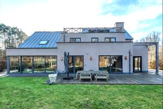 <p><strong>Quares by Trevi presenteert: Puur vakantiegevoel en privacy in een knappe villa aan het natuurgebied</strong></p>
<p>Geïnspireerd op de stijl van Piet Boon, kenmerkt deze villa zich door strakke architectuur, technische snufjes en kwaliteitsvolle, hoogwaardige materialen. Tijdloos design, mooie zichtlijnen en veel lichtinval zorgen voor rust en een direct vakantiegevoel. Topmaterialen zoals Corian, eik en notenhout sieren de woning. Domotica, warmtepompen, airco en een vingerafdrukscanner bieden modern comfort.</p>
<p><strong>De belangrijkste troeven op een rij:</strong></p>
<ul>
<li><strong>Toplocatie:</strong> Rustige, doodlopende straat aan een natuurgebied, vlak bij de Golf van Keerbergen.</li>
<li><strong>Wellness:</strong> binnenzwembad met jetstream & aansluitende badkamer, zwemvijver en luxe poolhouse.</li>
<li><strong>Ruimte:</strong> 6 slaapkamers, meerdere dakterrassen, home cinema en grote, droge kelder.</li>
<li><strong>Techniek:</strong> Uitgerust met warmtepompen, airco, domotica en camerabewaking.</li>
</ul>
<p><strong>INDELING</strong></p>
<p><strong>Gelijkvloers:</strong> Inkomhal met vestiaire en gastentoilet; wasplaats; bureau; royale leefruimte met open haard en tuinvisie; home cinema/eetkamer; inpandig west-terras met open haard. De luxe leefkeuken heeft een eiland, Gaggenau-toestellen, wijnkoeler en Quooker. Aansluitend ligt de wellnessruimte met binnenzwembad (ionisatie & jetstream, perfect werkend, nu afgedekt als relaxruimte) die baadt in het licht, en een badkamer met vrijstaand bad, douche en toilet.</p>
<p><strong>Kelder:</strong> Grote, droge kelder met actieve ventilatie, verdeeld in 6 ruimtes (ideaal als mancave, fitness, wijnkelder) plus de technische installaties.</p>
<p><strong>Eerste verdieping:</strong> Vijf slaapkamers met massieve parket en airco. De master bedroom heeft een en-suite dressing en privé-dakterras. Verder zijn er drie slaapkamers (waarvan één met terras), een zeer grote kamer boven het zwembad, apart toilet en een badkamer met ligbad, douche, bidet en dubbele lavabo.</p>
<p><strong>Tweede verdieping:</strong> Zesde slaapkamer of studio met toegang tot een groot dakterras achteraan en een terras vooraan.</p>
<p><strong>Buitenruimte:</strong> Volledig omheind perceel met automatische poort. Oprit voor 4 auto's, garage en berging. Het poolhouse heeft een douche, toilet, berging en overdekt terras met infraroodverwarming. De tuin biedt diverse terrassen, een zwemvijver met circulatiepomp en een origineel tuinhuis waarin een boom geïntegreerd is.</p>
<p>Heb je interesse? Maak een afspraak met Tinne Schotsmans op <strong>0477 60 21 99</strong> of via <strong>tinne.schotsmans@quares-trevi.be</strong>.</p>
<p></p>