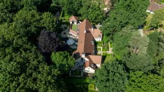 Villa spacieuse conçue par l'architecte Rutten, située dans un excellent emplacement à Oud-Turnhout, sur un magnifique terrain orienté sud-ouest de 2 985 m². La villa a une surface habitable de 900 m² et comprend un espace de vie très spacieux avec 2 salons, un bureau, une salle à manger et une cuisine. De plus, il y a une piscine intérieure avec salle de fitness et sauna, une suite parentale avec salle de bains attenante, 3 chambres, une deuxième salle de bains, une partie séparée avec salon, cuisine ouverte, salle de douche et chambre. Grenier aménagé avec accès séparé par un escalier extérieur. Annexe séparée (aménagée en tant que maison d'hôtes). Joli jardin aménagé avec places de parking à l'avant, étang avec terrasses à l'arrière.<br /><br />Rez-de-chaussée :<br />Le hall d'entrée spacieux mène à gauche à l'espace de vie. Celui-ci comprend un salon très spacieux avec coin cheminée, un deuxième coin salon ou télévision, un espace bureau et un accès à une salle de dégustation de vin. La salle à manger relie le salon à la cuisine très spacieuse. La cuisine est entièrement équipée avec tous les appareils (y compris four à air pulsé, micro-ondes, lave-vaisselle, réfrigérateur américain, plaque à induction, wok, friteuse,..). Coin petit-déjeuner et coin salon dans la cuisine. À côté de la cuisine, un deuxième coin repas ou espace de réception pour les invités. Espace bien-être avec piscine intérieure chauffée, salle de fitness, sauna, bar, cabine de change, grande douche à l'italienne, toilettes et accès séparé côté rue. Les doubles portes coulissantes donnent un accès direct à la terrasse avec auvent. Garage double intégré. Divers espaces de rangement, ainsi qu'une grande cave avec équipements techniques.<br /><br />Premier étage :<br />L'escalier en pierre naturelle mène à l'étage supérieur. Ici, vous trouverez un studio séparé avec salon, kitchenette ouverte, chambre et salle de douche avec toilettes. En outre, à cet étage, il y a une salle de bains et 3 chambres d'amis, dont une aménagée en espace bureau. Enfin, la suite parentale avec espace nuit, dressing et salle de bains attenante aménagée avec baignoire, 2 lavabos, toilettes et douche.<br /><br />Grenier :<br />Le grenier est accessible par un escalier fixe, mais aussi par un escalier extérieur. Il est entièrement aménagé et peut être utilisé à diverses fins (loisirs, bureau, chambres supplémentaires,..).<br /><br />Jardin :<br />Le jardin est entièrement aménagé avec des terrasses et un étang. Annexe séparée avec places de parking à l'avant. Actuellement aménagée en tant que maison d'hôtes.<br /><br />Détails :<br />- emplacement avantageux à proximité d'un supermarché, écoles, E34 (Anvers-Eindhoven),... dans un environnement résidentiel.<br />- très bon classement PEB (étiquette B - 168 kWh/m²)<br />- pas d'amiante<br />- surface habitable de plus de 900 m² !<br />- espace bien-être entièrement aménagé