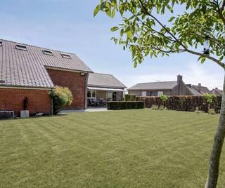 Het wordt steeds zeldzamer om een solide gebouwde villa op een royaal perceel van 15are te vinden die bovendien volledig klaar is voor de toekomst. Deze uitzonderlijk goed onderhouden villa combineert een tijdloze, kwalitatieve bouw met hedendaags wooncomfort en een indrukwekkend pakket aan energiezuinige technieken. Met een bewoonbare oppervlakte van ca. 275 m², vijf slaapkamers, twee luxueuze badkamers en een EPC-score van slechts 129 kWh/m² per jaar is deze villa de ideale gezinswoning voor wie op zoek is naar ruimte, comfort en duurzaamheid.<br /><br />Via de ruime inkomhal betreedt u de woning. Hier bevinden zich drie slaapkamers, waarvan één momenteel is ingericht als bureel. Verder vindt u hier een gastentoilet, een stijlvolle en functionele keuken en een bijzonder ruime, lichtrijke leefruimte waar grote raampartijen zorgen voor een aangename lichtinval. Vanuit de woonkamer heeft u rechtstreeks toegang tot het mooie balkonterras aan de voorzijde van de woning met zicht over het Raspaillebos. De hoogwaardige badkamer op het gelijkvloers straalt luxe uit en is uitgerust met een ligbad, een ruime inloopdouche en een dubbele wastafel. De bovenverdieping omvat nog twee ruime slaapkamers en een tweede badkamer. Ideaal als aparte verdieping voor kinderen, gasten of een inwonend familielid. De kelderverdieping biedt tal van praktische mogelijkheden en omvat een garage, een technische ruimte en voldoende opbergruimte. Ook buiten heeft deze eigendom heel wat te bieden. De prachtig aangelegde tuin vormt een groene oase waar u in alle rust kunt genieten van het buitenleven. Het ruime terras nodigt uit tot gezellige zomeravonden met familie en vrienden. Daarnaast beschikt de woning over een gemetselde berging die mooi aansluit op de woning én een afzonderlijke houten tuinberging achteraan het perceel. Bovendien is achteraan het landelijk zicht over de velden van onschatbare waarde.<br /><br />Troeven:<br />Perceel van 15are en straatbreedte van 25m<br />Ca. 275 m² bewoonbare oppervlakte<br />5 slaapkamers<br />2 stijlvolle badkamers<br />Ruime en lichtrijke leefruimte<br />Balkonterras aan de voorzijde<br />Grote aangelegde tuin met ruim zonneterras<br />Energiezuinig (EPC: 129 kWh/m² per jaar)<br />24 zonnepanelen met thuisbatterij<br />Zonneboiler<br />Nieuwe gascondensatieketel<br />Regenwaterput<br />Lucht-luchtairco's in alle slaapkamers<br />Elektrische rolluiken<br />Elektrische zonnewering over volledige achterterras<br />Laadpaal voor elektrische wagen<br />Elektriciteit conform<br />Asbestveilig