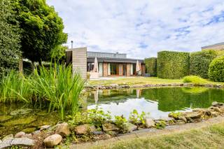 Op zoek naar rust, ruimte en groen, zonder in te boeten aan wooncomfort? Deze zeer goed onderhouden en instapklare woning combineert een royale bewoonbare oppervlakte van maar liefst 212 m² met een prachtig perceel van 1.600 m² en een heerlijke zuidgerichte tuin met zwemvijver.<br /><br />De eetkamer en leefruimte geniet van een mooi zicht op het omliggende groen en sluit aan op de moderne keuken, die in 2010 werd vernieuwd en voorzien is van alle nodige toestellen. Verder beschikt de woning over drie slaapkamers, voorzien van rolluiken en een gerenoveerde badkamer met dubbele lavabo, douche en bad (in 2021). De ruime inpandige (automatische) garage met bijkomende bergruimte zorgt voor heel wat praktisch comfort en mogelijkheden.<br /><br />De zuidgerichte tuin, de prachtige zwemvijver en de privacy zijn hier zonder twijfel een van de grootste troeven en zorgt voor een echt vakantiegevoel in eigen tuin. Achteraan in de tuin bevindt zich ook een tuinhuis.<br /><br />Daarnaast werd de woning doorheen de jaren goed onderhouden en verder verbeterd.<br />- Nieuwe condenserende gasketel geplaatst in 2023<br />- Luchtverwarmingsunit vernieuwd in 2023<br />- Hoogrendementsglas over de volledige woning (2019)<br />- Zonnepanelen en thuisbatterij (2022)<br /><br /><u>Troeven</u><br />Instapklare en zeer goed onderhouden woning<br />Perceel van 1.600 m²<br />Prachtige zuidgerichte tuin<br />Zwemvijver<br />Grote inpandige garage met bergruimte<br />Conforme elektrische installatie<br />Asbestveilig<br />Omgeven door veel groen met prachtige natuur- en wandelgebieden en het Pidpabos<br />Vlotte bereikbaarheid dankzij de nabijheid van de autosnelweg<br />Goede verbindingen met het openbaar vervoer<br /><br />Een bijzonder aangename woning voor wie houdt van ruimte, privacy en groen en tegelijk op zoek is naar een woning die meteen klaar is om in te trekken.<br /><br />Wilt u graag een bezoek inplannen? neem contact op met babette@myhomevastgoed.be of bel 0470/943624