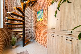 Op een centrale en vlot bereikbare ligging langs de Antwerpsesteenweg in Malle bevindt zich dit uitzonderlijk ruim duplex appartement met een bewoonbare oppervlakte van ca. 228 m². Het pand combineert ruimte, comfort en een zeer energiezuinige uitrusting, en beschikt over een privatieve inkom, inpandige garage, zonnig terras en privatieve tuin.<br />Indeling:<br />Via de privatieve inkom op het gelijkvloers met toegang tot de garage, bereik je de eerste verdieping. Hier vind je een ruime en lichtrijke leefruimte met zithoek en eetgedeelte, aansluitend een ingerichte keuken met toegang tot een zonnig terras van ca. 28 m². Verder zijn er drie volwaardige slaapkamers, een vernieuwde badkamer (2019), aparte wasruimte, technische berging en afzonderlijk toilet.<br />De bovenste verdieping is ingericht als een volwaardige studio met leefruimte en kitchenette, aparte slaapkamer en een tweede badkamer met douche en toilet. <br />Ideaal als extra woonruimte, bureau of gastenverblijf.<br />Achteraan het gebouw bevindt zich een privatieve tuin met veel privacy, die bij verkoop netjes wordt opgeleverd.<br />We sommen nog even alle troeven op; <br />4 slaapkamers + aparte studio<br />Inpandige garage met automatische sectionale poort (2020)<br />Zonnig terras van 28 m² + tuin<br />Bouwjaar 1989 met talrijke renovaties en upgrades<br />Elektrische installatie conform<br />Asbestveilig attest aanwezig<br />Alarmsysteem aanwezig<br />Zeer energiezuinig wonen dankzij label B:<br />26 zonnepanelen (2018 &amp; 2024)<br />Huawei hybride omvormer 10 kW + batterij 15 kWh<br />Zonneboiler Vaillant (2019)<br />Warmtepomp airco (2021)<br />Pelletkachel (2018)<br />PVC ramen (2017) met hoogrendementsdubbel en driedubbel glas + vliegenramen<br />Plat dak geïsoleerd (2018)<br />Velux dakraam (2021)<br />Vernieuwde badkamer (2019)<br />Aandeel gemene delen 504/ 1000 sten /privatieve meters <br /><br />Dit duplex appartement biedt een unieke combinatie van ruimte, energiezuinigheid en flexibiliteit, ideaal voor grote gezinnen, thuiswerk of combinatie wonen/werken.<br />Een zeldzame opportuniteit met veel potentieel op een centrale ligging in Malle.