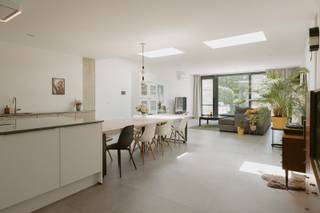 <p>Rijwoning 210m² | Ingrijpende energetische renovatie | EPC A | Zwijndrecht</p><p>🌐 Ontdek alle foto's en boek een bezichtiging op www.pastoorcoplaan23.be</p><p>Deze volledig gerenoveerde rijwoning (210 m²) combineert topkwaliteit met directe bewoonbaarheid. In december 2017 aangekocht en tot 2022 grondig herbouwd door de eigenaar-dakwerker — met dezelfde precisie en garanties als een professionele werf.</p><p>GV: Riante open leefruimte met plafonds van 2m95. Grote keramische tegels op vloerverwarming. Elektrisch bedienbare Velux dakkoepel. Groot schuifraam (5m × 2,8m) naar het zonnige terras en de ZW-tuin. Volledig uitgeruste maatwerkkeuken met kookeiland: AEG inductiekookplaat (3-fase), AEG oven, AEG vaatwasser, Zanussi koelkast en diepvries, Novy dampkap in het plafond. Domoticasysteem (licht, ventilatie, dampkap, rolluik, airco) via app bedienbaar. Apart toilet.</p><p>1e verdieping: Twee volwaardige kamers met kwaliteitsvolle laminaatvloer (Quick-Step). Ruime badkamer met dubbele inloopdouche, dubbele lavabo, ingebouwd toilet en designradiator. Aparte wasruimte met maatwerkkast in massief multiplex. Technische ruimte met Vaillant Ecotec Plus ketel.</p><p>2e verdieping — master suite (54 m²): Vrijstaand bad midden in de kamer, originele houten dakbalken, drie elektrisch bediende Velux dakramen op zonne-energie met rolluiken en zonwering, schuifraam naar klein terras. Airconditioning. Voorbereid voor opsplitsing in 2 slaapkamers + badkamer (leidingen reeds voorzien).</p><p>Technieken &amp; duurzaamheid: 10 zonnepanelen (SolarEdge, 4,2 kW) · Duco ventilatiesysteem type C · Airconditioning op elke verdieping (LG) · Regenwaterput 5.000L · Droge kelder · Fietsenberging voorzijde.</p><p>Troeven: EPC label A (e-peil 42) · 5 jaar vrijstelling onroerende voorheffing · KI € 423 · Ingrijpende energetische renovatie · Direct klaar om in te trekken.</p><p>📅 Bezichtigingen uitsluitend via www.pastoorcoplaan23.be<br />✉️ Vragen?</p>