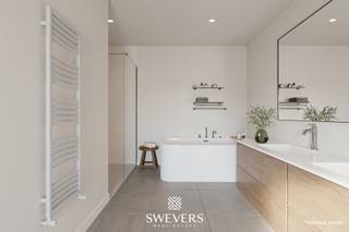 Voor meer info en foto’s, surf naar www.swevers.be – Op een centrale ligging in Helchteren vinden we dit instapklare nieuwbouwappartement (112 m²) op het gelijkvloers. U geniet hier van maximale privacy, zonder gemeenschappelijke kosten. Het bevat een zeer ruime, open leefruimte en keuken gericht naar de tuin die aangelegd wordt en voorzien van terras. Verder beschikt het appartement over een vrijstaande garage en ruime berging. De slaapkamers meten respectievelijk 16m² en 10m², gelegen naast de badkamer met ruimte voor bad en douche. Een ruime inkomhal en apart toilet maken het af. Zonnepanelen, vloerverwarming, warmtepomp en een regenwaterput vormen de kers op de taart. Winkels, scholen en openbaar vervoer liggen binnen 500 meter, en ontspanning vindt u vlakbij. De afwerking ligt nog niet vast en kan dus nog naar eigen wensen ingevuld/aangepast worden. Zelfs casco+ is mogelijk indien gewenst. Voor meer informatie, bel 011 255 155. Bron bewoonbare oppervlakte: EPC – verslag.