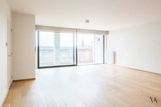 Op de 7e verdieping bevindt zich dit ruime en lichtrijke appartement van meer dan 130m² met een uitzonderlijk uitzicht over de Leuvense jachthaven, het historische stadscentrum en verschillende historische gebouwen.<br /><br />Je betreedt het appartement via de inkomhal met een eerste ruime (was)berging en apart toilet. Verder door kom je in de royale leefruimte met open en volledig geïnstalleerde keuken. Van hieruit heb je via grote schuiframen toegang tot het zonnige terras met zicht over de Leuvense jachthaven en het historische centrum. Hier is tevens een extra berging aanwezig.<br /><br />In de nachthal bevinden zich 2 erg ruime slaapkamers, een vernieuwde (2020) badkamer met inloopdouche en dubbele lavabo en nog een derde bergruimte. Dankzij het gunstige EPC A woon je bovendien energiezuinig en comfortabel.<br /><br />Een ondergrondse autostaanplaats (nr. 96 op niveau -1) kan gehuurd worden voor 100 EUR per maand. Het appartement is onmiddellijk beschikbaar.<br /><br />Een unieke woonkans voor wie op zoek is naar ruimte, comfort en een topligging met een van de mooiste uitzichten van Leuven.<br /><br />Contacteer ons voor meer info of een bezoek ter plaatse.