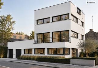 Een woning met een verhaal, een uitgesproken architecturale identiteit en een karakter dat vandaag nauwelijks nog te vinden is. Huize de Brem, ontworpen door architect Brauns, is een markante modernistische woning uit 1933 en geniet een beschermd statuut als monument.<br /><br />Met haar strakke lijnvoering, horizontale gevelcompositie, grote glaspartijen en heldere volumewerking is Huize de Brem een bijzondere getuige van het modernistische gedachtegoed. Hier koopt u dan ook niet alleen een woning, maar een stukje architectuurgeschiedenis op een herkenbare locatie in Hasselt.<br /><br />Volgens het EPC beschikt de woning over een bruikbare vloeroppervlakte van 213 m² (bron EPC) en een beschermd volume van 647 m³.<br /><br />Architectuur met een beschermd karakter<br /><br />Het beschermde statuut vormt een essentieel onderdeel van de identiteit van Huize de Brem. De architecturale kwaliteiten en historische eigenheid maken van het pand een uitzonderlijk aanbod voor wie bewust op zoek is naar vastgoed met authenticiteit en erfgoedwaarde.<br /><br />Dat betekent tegelijk dat een toekomstige renovatie met respect voor het oorspronkelijke ontwerp en de erfgoedwaarden dient te gebeuren. Ook het EPC wijst hier expliciet op: de gebruikelijke energetische aanbevelingen houden niet automatisch rekening met de erfgoedwaarden van een beschermd monument en bepaalde ingrepen kunnen daardoor niet of slechts aangepast uitgevoerd worden. Een renovatietraject vraagt hier dus om een doordachte, erfgoedvriendelijke benadering.<br /><br />Een bijzondere combinatie van wonen en werken<br /><br />De royale oppervlakte en de functionele opbouw van de woning bieden bovendien interessante mogelijkheden om wonen en werken onder één architecturaal dak samen te brengen.<br /><br />Huize de Brem kan daardoor bijzonder aantrekkelijk zijn voor bijvoorbeeld een vrij beroep, praktijk, kantoor, architecten- of ontwerpbureau, consultancy of een andere professionele activiteit die baat heeft bij een representatieve omgeving.<br /><br />De uitgesproken architectuur verleent een professionele activiteit bovendien een identiteit die een conventionele kantooromgeving zelden kan bieden. Tegelijk kan het private gedeelte zijn uitgesproken woonfunctie behouden.<br /><br />Huize de Brem is daarmee niet alleen interessant voor de architectuurliefhebber, maar ook voor de ondernemer of vrije beroeper die op zoek is naar een karaktervolle woon- én werkomgeving in Hasselt.<br /><br />Hoger gelegen tuin en twee dakterrassen<br /><br />Ook de buitenruimtes dragen bij aan het uitzonderlijke karakter van het geheel. Achter de woning bevindt zich een hoger gelegen tuin, die een verrassend groene tegenhanger vormt voor de uitgesproken architectuur.<br /><br />Daarnaast beschikt Huize de Brem over twee dakterrassen. Deze buitenruimtes sluiten bijzonder mooi aan bij het modernistische concept van de woning en creëren verschillende mogelijkheden om binnen en buiten met elkaar te verbinden.<br /><br />De tuin en beide dakterrassen bieden ruimte om te ontspannen, gasten te ontvangen of eenvoudigweg van een eigen buitenplek te genieten. Juist de combinatie van verschillende buitenruimtes maakt het pand extra interessant voor wie wonen en eventueel werken op hetzelfde adres wil verenigen.<br /><br />Dubbele garage<br />Ook praktisch heeft Huize de Brem een belangrijke troef: een dubbele garage. In een stedelijke context is parkeergelegenheid een aanzienlijke meerwaarde, en zeker bij een woning waar privé- en professioneel gebruik gecombineerd kunnen worden.<br /><br />De dubbele garage, de hoger gelegen tuin en de twee dakterrassen maken het aanbod van deze architectuurwoning dan ook opmerkelijk compleet.<br /><br />EPC – renovatiepotentieel met respect voor het erfgoed<br /><br />Huize de Brem beschikt momenteel over EPC-label F, met een berekende energiescore van 605 kWh/(m² jaar). Het EPC vermeldt een bruikbare vloeroppervlakte van 213 m². De woning voldoet vandaag niet aan de energiedoelstelling 2050.<br /><br />Het certificaat geeft verschillende energetische aandachtspunten aan, maar bij Huize de Brem moet dit steeds worden bekeken vanuit het bijzondere beschermde karakter van het gebouw. Het EPC waarschuwt expliciet dat de standaardaanbevelingen geen rekening houden met de erfgoedwaarden en daardoor niet zonder meer toepasbaar zijn.<br /><br />Dit opent voor een nieuwe eigenaar de mogelijkheid om samen met gespecialiseerde architecten en erfgoeddeskundigen te onderzoeken hoe hedendaags wooncomfort, energieprestaties en behoud van de oorspronkelijke architectuur op een kwalitatieve manier met elkaar kunnen worden verzoend.<br /><br />Voor wie méér zoekt dan een woning<br /><br />Huize de Brem is geen doorsnee vastgoed. Het is een pand voor iemand die de kracht van authentieke architectuur herkent en bewust kiest voor een woning met geschiedenis en persoonlijkheid.<br /><br />De combinatie van modernistische architectuur van architect Brauns, het beschermde karakter, 213 m² bruikbare vloeroppervlakte volgens EPC, twee dakterrassen, een hoger gelegen tuin, een dubbele garage en de mogelijkheid om wonen en werken te combineren, maakt dit tot een zeldzaam aanbod in Hasselt.<br /><br />Een plek om te wonen.<br />Een plek om te werken.<br />Een plek om architectuur te beleven.<br /><br />Huize de Brem – Kuringersteenweg 134, Hasselt. Een beschermd modernistisch huis met een verleden én potentieel voor een nieuwe toekomst.<br /><br />Professioneel gebruik, verbouwingen en energetische ingrepen zijn steeds onder voorbehoud van de toepasselijke stedenbouwkundige voorschriften, eventuele vergunningen en de voorwaarden verbonden aan het beschermde statuut.