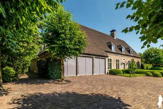 <p><strong>Prachtige villa met een bewoonbare oppervlakte van 512 m²</strong></p>
<p>Deze unieke, statige villa is prachtig gelegen <strong>nabij het centrum van Hoogstraten</strong> en biedt een schitterend uitzicht over het <strong>omliggende groen en landschap</strong>.</p>
<p>U betreedt de woning via een ruime inkomhal met een hoog plafond. Vanuit de inkomhal komt u in de <strong>royale leefruimte van circa 81 m²</strong>, voorzien van een <strong>karaktervolle antieke schouw en houtkachel</strong>. Dankzij de <strong>grote raampartijen</strong> geniet u vanuit de woonkamer van een prachtig uitzicht over het terras en de <strong>fraai aangelegde tuin.</strong></p>
<p>Aansluitend bevindt zich de<strong> sfeervolle woonkeuken</strong>, uitgerust met alle nodige inbouwapparatuur. Verder beschikt de woning over een praktische berging en een ruime wasplaats.</p>
<p><span>Een bijzondere troef van deze woning is de </span><strong><span>afzonderlijke polyvalente ruimte van ca. 100 m²</span></strong><span>, die perfect kan worden ingericht als kantoor-, praktijk- of hobbyruimte. De ruimte omvat een gelijkvloerse verdieping van ca. 50 m² en een bovenverdieping van eveneens ca. 50 m², die via een trap bereikbaar is. </span><span>Dankzij de </span><strong><span>aparte ingang aan de achterzijde van de woning</span></strong><span> kan deze ruimte afzonderlijk van het woongedeelte worden gebruikt. Hierdoor is ze uitermate geschikt voor de uitoefening van een </span><strong><span>vrij beroep, praktijk of kantoor aan huis</span></strong><span>, maar biedt ze ook tal van mogelijkheden als hobby-, werk- of polyvalente ruimte.</span></p>
<p>Op de verdieping bevindt zich de <strong>ruime masterbedroom met een aparte dressingkamer en badkamer.</strong> Daarnaast zijn er <strong>vier extra slaapkamers</strong>, waarvan één beschikt over een eigen badkamer. In totaal zijn er <strong>drie volledig ingerichte badkamers</strong> aanwezig. Een praktische linnenkamer maakt deze verdieping compleet.</p>
<p>De <strong>ruime zolderverdieping</strong> doet momenteel dienst als opbergruimte en biedt bovendien tal van mogelijkheden voor verdere invulling. De inpandige <strong>garage </strong>biedt plaats aan maar liefst drie auto's. Verder is er ook een handige <strong>wijnkelder </strong>aanwezig.</p>
<p>Ook buiten heeft deze villa veel te bieden. De woning beschikt over een <strong>prachtig aangelegde en volledig omheinde tuin</strong> met een vijver en meerdere terrassen. Hierdoor zijn er verschillende aangename plekken om te genieten van de rust en het groen rondom de woning. Daarnaast is er een <strong>ruime tuinberging van circa 50 m²</strong>. De tuin is voorzien van <strong>buitenverlichting</strong> en een recent vernieuwd automatisch <strong>beregeningssysteem</strong>. Een eigen waterput voorziet in zuiver drinkbaar water.</p>
<p>Op technisch vlak is de woning eveneens uitstekend uitgerust met onder meer een <strong>alarmsysteem en domotica.</strong> Bovendien werd de technische installatie in 2023 volledig gereviseerd.</p>