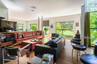 <p><strong>In de gegeerde Pulhofwijk te Berchem, aan het Nachtegalenpark, vindt u deze ruime en lichtrijke halfopen architectenwoning met zonnig georiënteerde tuin.</strong></p>
<p>De veelzijdige indeling leent zich zowel voor een comfortabel gezinshuis als voor een combinatie van wonen en werken. Ook co-housing of kangoeroewonen behoort tot de mogelijkheden: samenleven onder één dak, met ruimte voor ieders privacy. Met tot vijf mogelijke slaapkamers en drie badkamers biedt deze woning de flexibiliteit om mee te groeien met uw gezin en woonwensen.</p>
<p>De lichtrijke inkomhal verwelkomt u en geeft rechtstreeks toegang tot de inpandige garage. Een niveau lager bevinden zich een eerste ruimte die ook als kantoor kan worden ingericht en een extra kantoor- of slaapkamer met een eigen badkamer, uitgerust met douche, wastafel en toilet. Een fijne plek om rustig te werken of gasten te ontvangen.</p>
<p>De zitruimte sluit aan op de lichtrijke eetkamer en de halfopen, volledig ingerichte keuken voorzien van opbergkasten en toestellen; een oven, kookplaat, dampkap en vaatwasser. Airconditioning zorgt hier voor extra comfort. De glazen deur geeft u toegang tot het terras met elektrische zonnewering en de aangelegde tuin. Een uitnodigende plek om buiten te eten of de dag ontspannen af te sluiten.</p>
<p>De verdieping biedt plaats aan de masterbedroom, een tweede slaapkamer en een ruime wasruimte die ook een andere invulling kan krijgen. De badkamer beschikt over een dubbele wastafel, een bad en een inloopdouche. Het toilet bevindt zich apart.</p>
<p>Ook bovenaan verrast deze woning. De hoogste verdieping is ingericht als studioverdieping, met een ruime leefruimte, een comfortabele open keuken en een eigen badkamer met wastafel, toilet en inloopdouche. Via een trap bereikt u de bijbehorende duplex-slaapkamer op de zolderverdieping. Deze opzet biedt extra mogelijkheden voor wie onder één dak wil samenleven en tegelijk ruimte voor privacy zoekt.</p>
<p>De inpandige garage en oprit maken de woning compleet.</p>
<p>Met een gunstig EPC, een asbestveilig attest en een conforme elektrische installatie beschikt deze woning bovendien over belangrijke troeven.</p>
<br /><span><strong>BIJZONDERHEDEN:</strong></span><br />* Zeer ruime en polyvalente archtecturale Halfopen bebouwing op absolute toplocatie in de gegeerde Pulhofwijk. <br />* Tot 5 slaapkamers mogelijk en 3 badkamers.<br />* Ruime inpandige garage met oprit <br />* Gunstige EPC, Asbestveilig en Electriciteit conform.