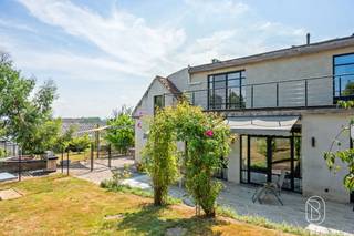 Ruim karakteristiek huis met 4 slaapkamers, een grote tuin en authentieke charme. Dit uitzonderlijke pand combineert de charme van een authentieke kleine boerderij met het comfort van een recente uitbreiding uit 2013. Met een woonoppervlakte van maar liefst 522 m² (te verifiëren aan de hand van het PEP), een perceel van 1 726 m² en een veelzijdige indeling is dit huis ideaal voor grote gezinnen, zelfstandigen of mensen die op zoek zijn naar een unieke woonervaring met veel ruimte.Indeling: entreehal, kantoor, apart gastentoilet, een grote, lichte woonkamer, een kantoor met mezzanine, bijkeuken/wasruimte, badkamer, keuken en een tweede gezellige woonkamer. Dankzij de praktische indeling is het bovendien mogelijk om op de begane grond een slaapkamer in te richten.Op de eerste verdieping bevinden zich vier ruime slaapkamers, een tweede badkamer, een wellnessruimte met infraroodsauna, een inloopkast, een terras grenzend aan de ouderslaapkamer en een bibliotheek/kantoor. Daarnaast beschikt het huis over een ruime en volledig geïsoleerde zolder, ideaal als extra opslagruimte.Buiten kunt u genieten van een prachtige tuin met verschillende terrassen en een eigen boomgaard met onder andere vijgen-, appel-, kersen-, perzik- en pruimenbomen. Het huis beschikt tevens over een garage en een ruime parkeerplaats die plaats biedt aan meerdere auto’s.Het oorspronkelijke linkergedeelte van het huis heeft zijn authentieke karakter behouden, terwijl het rechtergedeelte in 2013 volledig is herbouwd en zowel op de begane grond als op de eerste verdieping is voorzien van vloerverwarming op aardgas. De hoofdslaapkamer en de bibliotheek zijn voorzien van airconditioning.Het huis straalt veel karakter uit dankzij de hoogwaardige en unieke afwerking, met onder meer prachtige binnendeuren vervaardigd uit deuren afkomstig van Indiase tempels en een gevarieerde keuze aan materialen zoals travertijn in de inkomhal, parket, leisteen in het kantoor, blauwe hardsteen aan de buitenkant en karaktervolle kasteeltegels in de tweede zitkamer. Bovendien zorgen de geïnstalleerde zonnepanelen voor een meerwaarde op het vlak van energie-efficiëntie. Te koop via Immo Beguin, uw vastgoedexpert sinds 2009.Meer informatie of een bezichtiging? Neem contact op met emmy@immobeguin.be