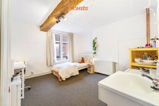 Deze karaktervolle studentenwoning beschikt over 7 comfortabele studentenkamers met gedeeld sanitair. Gelegen op een uitermate strategische locatie in de bekende Naamsestraat, bevindt dit pand zich op een steenworp afstand van de faculteiten, het historisch centrum, en alle nodige voorzieningen. Dankzij deze toplocatie is leegstand vrijwel uitgesloten! Het gebouw biedt een ruime inpandige fietsenstalling en een gezellige gemeenschappelijke keuken waar studenten elkaar kunnen ontmoeten. Daarnaast is er een gedeelde douche en zijn er twee toiletten aanwezig. De huurcontracten hebben een looptijd van 12 maanden, en de kosten voor verbruik, internet, en schoonmaak van de gemeenschappelijke delen worden verrekend via een kostenforfait van €90 per maand. Momenteel is het pand volledig verhuurd en voorzien van een conformiteitsattest dat geldig is tot 2030. Een reclamepaneel aan de zijmuur zorgt bovendien voor een bijkomende opbrengst. Jaarlijkse netto-opbrengst van €35.904 met nog opwaarts potentieel. Interesse? Neem contact op via 016 22 82 22 of info@homies.be.