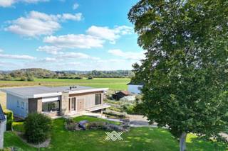 Deze statige woning die in 2022 volledig werd gerenoveerd, combineert karakter met moderne charme. Met een bewoonbare oppervlakte van 180 m² is de villa ideaal voor gezinnen die op zoek zijn naar ruimte, licht en comfort. De indeling van de woning is perfect afgestemd op modern wooncomfort, met ruimtes die zorgen voor een gevoel van openheid en verbinding tussen binnen en buiten. De grote ramen zorgen voor een overvloed aan natuurlijk licht en bieden een prachtig uitzicht op de voor- en achtertuin en de groene omgeving.<br />De locatie is een sterke troef: op loopafstand van supermarkten, winkels en het centrum van Berchem en Kerkhove. Genieten van de prachtige fauna en flora kan je in het nabijgelegen schilderachtige natuurgebied de Scheldemeersen of voor wie houdt van de rust biedt de jachthaven aan de Scheldekaai een mooi decor.<br /><br />Bij binnenkomst in de woning kom je in de uitnodigende inkomhal met gastentoilet die toegang biedt tot de open leefruimte, voorzien van een zit- en eethoek en een open keuken. De moderne leefkeuken met kookeiland biedt toegang tot een aparte trap die leidt naar de benedenverdieping, waar je een wasruimte, berging en een ruime garage vindt. Via de leefkeuken of de garage bereik je het terras en de achtertuin, waar je kunt genieten van adembenemende uitzichten over de velden van de Vlaamse Ardennen. Er zijn drie volwaardige slaapkamers en een moderne badkamer, uitgerust met douche, lavabo en toilet. Een prachtig balkon aan de voor- en rechterzijde van de woonkamer voegt extra allure toe. <br /><br />De woning is hoogwaardig afgewerkt met duurzame natuurlijke materialen. Geniet van de moderne voorzieningen, waaronder recente zwarte aluminium ramen, uitgewerkte houten kasten rond de verwarmingsinstallaties en stijlvolle ingemaakte kasten in de leefruimte, de slaapkamers en de badkamer.<br /><br />De woning kan ook gekocht worden als opbrengsteigendom. De woning wordt momenteel verhuurd (vrij max. 6 maanden na akte). Deze eigendom heeft ook het potentieel om in de onderste verdieping een handelszaak te starten. <br /><br />EPC: 297(C) / Centrale verwarming op stookolie / Asbestveilig / Elektriciteit conform<br /><br />Wilt u deze woning zelf ervaren? Neem dan vrijblijvend contact op voor meer informatie of om een bezoek in te plannen via dimitri@landbergh.be of 09 278 78 79.