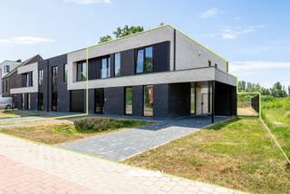 Ontdek deze rustig gelegen BEN-nieuwbouwwoning waar ruimte, comfort en energiezuinig wonen naadloos samenkomen. Met een bewoonbare oppervlakte van maar liefst 242 m² biedt deze stijlvolle woning alle hedendaagse wooncomfort op een uitstekende locatie, in de onmiddellijke nabijheid van winkels, scholen, openbaar vervoer en de belangrijkste verbindingswegen (A12, N16 en E19).<br /><br />Via de ruime inkomhal betreedt u de woning, waar u meteen wordt verwelkomd door een aangename lichtinval en een doordachte indeling. Op het gelijkvloers bevinden zich een gastentoilet en een bijzonder lichtrijke leefruimte met een volledig uitgeruste open keuken. Deze moderne keuken is afgewerkt met kwalitatieve toestellen, waaronder een inductiekookplaat met geïntegreerde dampkap, vaatwasser, oven, combi-microgolfoven, bordenverwarmer, koelkast met diepvriesvak en een dubbele spoelbak. Dankzij de grote raampartijen geniet u vanuit de leefruimte van een mooi zicht op de tuin en heeft u rechtstreeks toegang tot het aangelegde terras en de zuidwestelijk georiënteerde tuin, waar u de hele namiddag en avond in alle rust van de zon kunt genieten.<br /><br />Verder beschikt het gelijkvloers over een praktische berging met wasplaats, voorzien van een spoelbak en aansluitingen voor een wasmachine en droogkast. Daarnaast is er een extra polyvalente ruimte die volledig naar wens kan worden ingericht als bureau, fitnessruimte, hobbykamer of praktijkruimte voor de uitoefening van een vrij beroep.<br /><br />Op de eerste verdieping bevinden zich vier volwaardige slaapkamers, een nachthal, een afzonderlijk toilet en een technische berging. De ruime master bedroom beschikt over een eigen dressing en een ensuite badkamer met inloopdouche en wastafel. De tweede badkamer is uitgerust met een ligbad, een ruime inloopdouche en een dubbele wastafel, waardoor ook grotere gezinnen alle comfort genieten.<br /><br />Ook op technisch vlak voldoet deze woning aan de hoogste normen. Zo is de volledige woning voorzien van vloerverwarming en airconditioning in zowel de leefruimte als alle slaapkamers. Dankzij de zonnepanelen en de BEN-norm geniet u bovendien van een bijzonder energiezuinige woning met een laag energieverbruik en een optimaal wooncomfort.<br /><br />Ook buiten werd aan alles gedacht. De tuin is volledig aangelegd en omheind, het terras en de oprit zijn reeds afgewerkt. De volledige woning is afgewerkt met duurzame en kwalitatieve materialen, waardoor u zorgeloos kunt genieten van een instapklare nieuwbouwwoning.