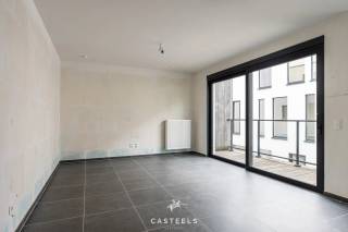 <br />Een nieuwbouwappartement geschikt voor jong en oud die rustig willen wonen in de Vlaamse Ardennen.<br /><br />Comfortabel en energiezuinig wonen in Kluisbergen. Dit nieuwbouwappartement heeft een gunstige ligging in het gebouw op de 1e verdieping. Hierdoor geniet u van extra lichtinval en een binnenpatio. Het appartement is reeds volledig afgewerkt; enkel de schilderwerken moeten nog worden uitgevoerd.<br /><br />De troeven van dit appartement:<br />-Unieke ligging: Met veel natuurlijke lichtinval en zicht op de binnenpatio.<br />-Energiezuinig &amp; toekomstbestendig: Dankzij de recentste isolatienormen en moderne bouwtechnieken geniet u van een uiterst lage energiefactuur en een aangenaam, constant binnenklimaat.<br />-Optimaal comfort: U geniet van het comfort van wonen op de 1e verdieping met een eigen, onderhoudsvriendelijk terras om in alle rust buiten te zitten.<br />-Volledig afgewerkt (incl. schilderwerken naar eigen smaak): Het appartement is helemaal instapklaar op de schilderwerken na. Deze zijn reeds inbegrepen in de prijs, waardoor u het kleuren- en  afwerkingspalet nog volledig naar eigen wens kunt kiezen.<br /><br />De lichtrijke leefruimte is voorzien van een prachtige tegelvloer en loopt naadloos over in de moderne, volledig geïnstalleerde open keuken. Daarnaast beschikt het appartement over één volwaardige slaapkamer, een berging en een ruime badkamer.<br /><br />Unieke gemeenschappelijke faciliteiten:<br />Naast uw privatieve terras heeft u direct toegang tot de grote, mooi aangelegde gemeenschappelijke tuin met een petanquebaan, een ontmoetingszaal voor bewoners, een infraroodcabine en een ruime, veilige fietsenberging.<br /><br />Uitstekende ligging &amp; bereikbaarheid<br />Het appartement is prachtig gelegen in het hart van de Vlaamse Ardennen, op een boogscheut van het Kluisbos en bekende wandel- en fietsroutes zoals de Oude Kwaremont.<br /><br />Ondanks de rustige en groene omgeving is de bereikbaarheid uitstekend:<br />-Verbindingen: Dankzij de nabijheid van de N60, N36 en N453 bereikt u vlot omliggende steden en gemeenten zoals Oudenaarde, Ronse, Avelgem, Maarkedal en Mont-de-l'Enclus. De snelweg E17 (oprit Waregem of Deerlijk) bevindt zich op slechts 15 tot 20 minuten rijden.<br />-Voorzieningen: Winkels voor de dagelijkse boodschappen (onder meer Delhaize, Spar en Carrefour Express), evenals lokale bakkers, slagers en apotheken bevinden zich in de directe nabijheid. Uitgebreider shoppen kan makkelijk in het nabijgelegen Oudenaarde of Ronse.<br />-Scholen: Verschillende basisscholen (zoals GBS De Start) en kinderopvangvoorzieningen liggen op wandel- of fietsafstand. Middelbare scholen in Ronse en Oudenaarde zijn eveneens vlot bereikbaar.<br /><br />Neem gerust contact met ons op voor meer informatie of om een bezoek in te plannen!<br />Stedenbouwkundige inlichtingen: in aanvraag.