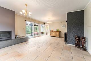 Deze goed onderhouden bungalow uit <strong>1977</strong> ligt in een rustige wijk nabij <strong>het centrum</strong>. De woning blinkt uit in haar praktische indeling en werd altijd met de grootste zorg onderhouden. Met een <strong>bewoonbare oppervlakte van 152 m²</strong> bevindt het volledige leefcomfort zich op het gelijkvloers, aangevuld met een handige eerste verdieping.<br /><br /><strong>Indeling en troeven:</strong>
<ul>
<li><strong>Gelijkvloers:</strong> Inkomhal met gastentoilet en een <strong>natuurstenen vloer </strong>die doorloopt in de keuken en de leefruimte met gezellige houtcassette. De zithoek en keuken (met fornuis, oven, frigo en vaatwas) sluiten aan op de veranda, die toegang geeft tot <strong>het zonnige terras</strong> <strong>en de tuin</strong>. Verder zijn er <strong>3 slaapkamers</strong> (in laminaat) en een badkamer met ligbad, dubbele lavabo en een tweede toilet.</li>
<li><strong>Eerste verdieping: </strong>Bereikbaar via een vaste trap en al voorzien van <strong>vernieuwde Velux-ramen</strong>. Deze ruimte onder het dak is ideaal te gebruiken als logeerkamer, hobbyruimte of extra berging.</li>
<li><strong>Garage: Dubbele garage</strong> met automatische poort en een handige regenwaterpomp.</li>
</ul>
<br /><strong>Technisch:</strong>
<ul>
<li><strong>Elektriciteit:</strong> Volledig <strong>conform!</strong></li>
<li><strong>Ramen:</strong> Grotendeels vernieuwd in <strong>PVC (2010) </strong>met rolluiken in de slaapkamers. Vernieuwde leidingen (badkamer & gastentoilet). Centrale verwarming op mazout.</li>
<li><strong>Renovatieplicht:</strong> Onderhevig aan de Vlaamse renovatieplicht (voornamelijk door het ontbreken van dakisolatie) — de ideale kans om meteen te isoleren naar eigen wens en te besparen op je energiefactuur.</li>
</ul>
<strong>Kortom, een solide en comfortabele thuis met enorm veel potentieel! Plan snel je bezoek en ontdek zelf alle troeven.</strong>