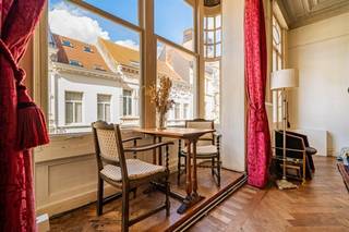 <h3><span>Polished by Time.</span></h3><p><br /> </p><p><span><strong>Locatie</strong></span><br /><br /><span>Zurenborg. Waar de straat nog een sociaal netwerk is. </span><br /><span>Sommige buurten hebben een postcode. Andere hebben een persoonlijkheid. </span><br /><span>De Arendstraat behoort zonder twijfel tot die tweede categorie. </span><br /><span>Ze ligt midden in Zurenborg, tussen de Grotehondstraat en de Dageraadplaats, in een wijk die nooit helemaal doorsnee Antwerpen is geworden. </span><br /><span>En gelukkig maar…</span><br /><span>Het is een plek voor wie graag in een stad woont, maar ook graag een buurt beleeft.</span><br />Hier investeer je in een woning én in vastgoed met een uitgesproken architecturale identiteit. Na renovatie kan dit een uitzonderlijk appartement worden onvergelijkbaar met het doorsnee aanbod.<br /><br /> </p><p><span><strong>Omschrijving</strong></span></p><p><br />Dit ruim karakterappartement op de eerste verdieping vormt het decor voor een renovatieproject met bijzonder veel potentieel.</p><p>De absolute blikvanger is de royale woonkamer aan de straatzijde. De hoge plafonds, sierlijke schouw en vooral de prachtige erker geven deze ruimte een bijna theatrale uitstraling. <br />Het daglicht valt royaal binnen en biedt vanuit de erker een mooie blik op de karaktervolle gevelrijen en het plein van Zurenborg. Het originele parket is vandaag wat dof ; eenmaal geschuurd en geboend kan het opnieuw een van de sterkste elementen van het interieur worden.</p><p>Aansluitend bevindt zich de eetkamer, eveneens met parket en mooie proporties. <br />Bijzonder is het centrale terras, als een kleine buitenkamer midden in het appartement. Zowel de eetkamer als de keuken kijken er via grote raamopeningen op uit. Met een doordachte renovatie kan hier een verrassend aangename, groene patio ontstaan: een plek voor koffie in de ochtend, planten, kruiden of een glas wijn aan het einde van de dag.</p><p>Verder zijn er een ruime slaapkamer<strong>,</strong> keuken en badkamer. Deze laatste vragen modernisering, maar precies daarin ligt de kans om hedendaags comfort toe te voegen zonder de ziel van het appartement uit te wissen. Een extra troef is de multifunctionele ruimte. Vandaag onderdeel van de circulatie, morgen misschien een royale inkomhal, thuiswerkplek, bibliotheek of – mits een aangepaste inrichting – een bijkomende slaapruimte. De vierkante meters zijn er; de nieuwe eigenaar bepaalt wat ermee gebeurt. Dit appartement is niet instapklaar – en dat is precies zijn aantrekkingskracht. Je krijgt alle ruimte om er iets heel bijzonders van te maken. </p><p><br /> </p><p><span><strong>Troeven</strong></span><br /><br />- de locatie an sich<br />- de authentieke elementen <br />- de buitenkamer<br />- het karakter van het geheel<br />- lage gemeenschappelijke kosten</p><p><br /> </p>