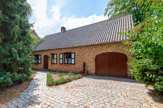 <p><span>Op een uitermate rustige en aangename locatie in Kapellen bevindt zich deze karaktervolle en verrassend ruime woning (166m²) met een warme, landelijke uitstraling, waarbij momenteel alles gelijkvloers werd georganiseerd. Thans beschikt de woning over twee volwaardige slaapkamers, één badkamer, een inpandige garage, een sfeervolle tuin en een uitzonderlijk grote zolderverdieping (123,75m²), welke U heel wat uitbreidingsmogelijkheden biedt. Het is zeker mogelijk om deze woning om te vormen naar een ruime gezinswoning met een vijftal slaapkamers en twee badkamers.</span></p><p><span>We betreden de woning langs de ruime inkomhal (met gastentoilet), welke ons links toegang geeft tot de royale leefruimte (40,30m²), welke voldoende plaats biedt voor een gezellige zithoek en een eetkamer. De houten balken, terracottavloer, schouwmantel en karaktervolle houtkachel zorgen voor een warme sfeer. Dankzij de vele raampartijen geniet de ruimte bovendien van veel natuurlijk licht. Het grote schuifraam zorgt ook voor een mooie verbinding met het terras en de volwassen groene tuin.</span></p><p><span>Aansluitend aan de leefruimte vinden we de ruime keuken (12,40m²), welke is voorzien van voldoende kast- en werkbladruimte en de volgende uitrusting: kookplaat (keramisch), dampkap, spoelbak, vaatwasser, oven en koelkast. Verder biedt de keuken ook nog voldoende plaats voor een gezellige ontbijthoek. Naast de keuken komen we dan de bijkeuken tegen, welke nog extra kastruimte biedt en waar ook de diepvriezer een plaats kreeg. Langs de bijkeuken kunnen we ook toegang nemen tot het terras.</span></p><p><span>Via de nachthal bereiken we het slaapgedeelte. De woning beschikt thans over twee ruime slaapkamers van respectievelijk 20,25m² en 14,00m². Verder biedt deze nachthal ons ook nog toegang tot de badkamer (met ligbad, dubbel lavabomeubel en toilet), welke ook rechtstreeks toegankelijk is vanuit de grootste slaapkamer, en de inpandige garage. In deze laatste vinden we naast de technische voorzieningen (elektriciteit, verwarming en ventilatie) ook de voorzieningen voor wasmachine en droogkast terug, net als een uitgietbak.</span></p><p><span>In de garage bevindt zich de vlizotrap, welke ons op de indrukwekkende zolderverdieping (123,75m²) brengt. Indrukwekkend qua oppervlakte en dus ook uitbreidingsmogelijkheden. De omvang van de zolderverdieping biedt bijzonder veel mogelijkheden. Bijkomende slaapkamer(s) en/of badkamer(s), een hobbyruimte, een bureau of een combinatie van dit alles.</span></p><p><span>Men koopt hier dus niet louter een volledig gelijkvloers georganiseerde woning, doch wel degelijk een woning met aanzienlijke uitbreidingsmogelijkheden binnen het bestaande bouwvolume.</span></p><p><span>De tuin met vijverpartij is als het ware een groene oase van rust, welke ook de nodige privacy biedt. Naast het terras (met zonneluifel) beschikt de woning ook over een overdekt terras, zodat men gedurende het grootste deel van het jaar van de aangename buitenruimte kan genieten. Met een tuinhuis en een bijkomende opslagplaats vinden we ook hier de nodige bergruimte terug.</span></p><p><span>Tenslotte beschikt men met de inpandige garage en een ruime oprit ook over voldoende parkeergelegenheid op eigen terrein.</span></p><p><span>In dezer is de energetische renovatieplicht van toepassing. Hieraan voldoet men echter al door de elektrische vloerverwarming af te koppelen en de ganse woning (met uitzondering van de garage) te voorzien van een A++ lucht/lucht warmtepomp. Dan gaat men immers meteen naar een energiescore van 214 kWh/(m²jaar), welk overeenstemt met een energielabel C. Wenst men de energetische renovatie te maximaliseren richting een energielabel A, dan zijn bijkomend nog de volgende werken noodzakelijk: plaatsen van zonnepanelen (6.000Wp), warmtepompboiler van 180 liter (A++), niet geïsoleerde gedeelte zoldervloer isoleren (10cm PIR met Rd 4,5) en plafond kruipruimte isoleren (10cm PIR in situ Rd 4,5).</span></p><p><span>Interesse gewekt? Wel, dan hoor ik graag van U! Bij voorkeur contact opnemen via telefoon en/of WhatsApp (mobiel nummer: 0478/95.01.51).</span></p>