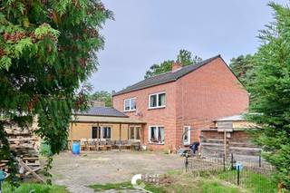 Ruime woning met 5 slaapkamers, verhuurde studio en polyvalente ruimte op een groene locatie.<br /><br />Deze ruime woning is gelegen in een bosrijke en rustige omgeving en biedt vooral veel ruimte en mogelijkheden. De woning is op te frissen, maar beschikt over een interessante indeling met maar liefst 5 slaapkamers, een aparte studio en een polyvalente ruimte die verschillende bestemmingen kan krijgen.<br /><br />De ligging is een absolute troef voor wie graag in het groen woont. Vanuit de woning bereik je op wandelafstand natuurgebied ’t Plat en verschillende wandel- en mountainbikeroutes. Ook gezinnen zitten hier goed: de lokale basisschool bevindt zich op fietsafstand.<br /><br />Naast de woning bevindt zich een aparte studio, die momenteel verhuurd is. Deze kan uiteraard ook op termijn een andere invulling krijgen, bijvoorbeeld als kangoeroewoning, gastenverblijf, Airbnb of als extra woonruimte voor een inwonend kind.<br /><br />Ook de polyvalente ruimte biedt heel wat mogelijkheden. Deze deed vroeger dienst als winkel en kan opnieuw gebruikt worden als handelsruimte, maar leent zich evengoed als hobbyruimte, atelier, praktijkruimte, speelruimte of man cave.<br /><br />INDELING<br /><br />Gelijkvloers:<br /><br />- Inkom rechtstreeks in de polyvalente ruimte/voormalige winkel<br />- Ruime woonkamer met houtkachel, veel lichtinval en zicht op de tuin<br />- Ingerichte keuken<br />- Wasplaats/berging<br />- Gastentoilet<br />- Stookplaats<br /><br />Eerste verdieping:<br /><br />- 5 slaapkamers<br />- Ruime badkamer met inloopdouche, toilet en lavabo<br /><br />Kelder:<br /><br />- Bergkelder<br /><br />Buiten:<br /><br />- Verschillende terrassen<br />- Zuidgerichte tuin<br /><br />Studio:<br /><br />- Inkomhal<br />- Leefruimte met open keuken<br />- Slaapkamer<br />- Berging<br />- Badkamer met douche, toilet, lavabo en aansluitingen voor wasmachine en droogkast<br /><br />TROEVEN:<br />+ 5 slaapkamers<br />+ Aparte, momenteel verhuurde studio<br />+ Polyvalente ruimte met tal van mogelijkheden<br />+ Zuidgerichte tuin<br />+ Veel ruimte voor gezinnen en hobby's<br />+ Bosrijke omgeving<br />+ Op wandelafstand van natuurgebied en wandel- en mountainbikeroutes<br />+ Basisschool op fietsafstand<br /><br />Een woning met veel potentieel en verschillende gebruiksmogelijkheden, ideaal voor wie niet bang is om de handen uit de mouwen te steken en graag zelf een woning naar eigen smaak en wensen wil opfrissen.<br /><br />Is deze woning iets voor jou? Contacteer ons en we helpen je graag dichtblij verder!