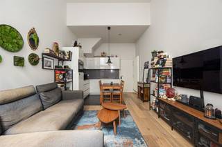 <p><span>Op zoek naar een tof appartement midden in de stad? Hier krijg je een lichte leefruimte met hoge plafonds, een gezellige stadskoer, een achteraan gelegen slaapkamer én een extra bureel op een extra verdieping. De warme parketvloer, nette afwerking en ligging vlak bij de Ossenmarkt krijg je er zo bij!</span></p><p><span>Veel licht, hoge plafonds & parket</span></p><p><span>Je komt binnen in de leefruimte met open keuken, waar de hoge plafonds (4.20m!) meteen voor een fijn ruimtegevoel zorgen. De mooie parketvloer loopt door in de zithoek en maakt het geheel warm en gezellig. Dankzij de hoge ramen valt er bovendien lekker veel daglicht binnen.</span></p><p><span>De witte keuken is strak en praktisch ingericht, met veel kastruimte, een grijs en ruim werkblad, spoelbak, kookplaat en ingebouwde oven. Er is plaats voor een eettafel vlakbij de keuken, terwijl je aan de andere kant makkelijk een ruime zithoek installeert. Een fijne open leefplek dus, zonder dat keuken en salon in elkaars weg zitten.</span></p><p><span>Vanuit de leefruimte stap je rechtstreeks de stadskoer op. Met een tafel, wat stoelen en groen maak je hier een gezellige buitenplek waar je bij mooi weer heerlijk buiten kunt eten.</span></p><p><span>Via de hal wandel je naar het gastentoilet, de slaapkamer en de badkamer. De slaapkamer ligt rustig achteraan en heeft dezelfde warme parketvloer. Extra leuk: ook van hieruit heb je rechtstreeks toegang tot de stadskoer.</span></p><p><span>De badkamer is strak afgewerkt met een grote inloopdouche, een dubbel lavabomeubel in houtlook en een grote spiegelkast. Alles wat je nodig hebt, zonder overbodige franjes. Ideaal!</span></p><p><span>Een verdieping extra</span></p><p><span>De houten spiltrap in de hal brengt je naar boven, waar je nog een verrassend grote extra ruimte hebt. Het aparte bureel is eveneens afgewerkt met parket, krijgt natuurlijk licht binnen en biedt meer dan genoeg plaats voor een fijne thuiswerkplek. Een hobbykamer, dressing of logeerplek kan hier natuurlijk evengoed.</span></p><p><span>Op de overloop is ook plaats voorzien voor de wasmachine, netjes uit de leefruimte. En spullen die je niet elke dag nodig hebt? Die kun je kwijt in de kelder. Voor de fiets is er een gemeenschappelijke fietsenstalling in het gebouw voorzien.</span></p><p><span>Midden in de stad </span></p><p><span>Je woont hier pal in het historische centrum van Antwerpen, vlak bij de gezellige Ossenmarkt en midden in de universiteitsbuurt. Terrasjes, restaurants, koffiebars en winkels heb je hier voor het uitkiezen, en ook de Paardenmarkt en Stadswaag liggen vlakbij. Voor tram en bus hoef je niet ver en ook het Centraal Station bereik je makkelijk te voet of met de fiets. Een echte stadsplek dus, met zowat alles binnen handbereik. </span></p><p><span> </span></p>
