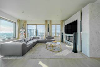 <p>Ontdek pure luxe op grote hoogte in dit uitzonderlijke appartement op de 20ste verdieping van residentie “Scheldezicht”, een architecturale eyecatcher in het geliefde Nieuw Zuid. Met een royale bewoonbare oppervlakte van ca. 212 m² en zonovergoten terrassen van ca. 140 m² geniet u hier in alle rust van een panoramisch uitzicht over de skyline van Antwerpen, de Schelde en het omliggende groen.</p>
<p>Via de stijlvolle inkomhal met vestiaire en gastentoilet betreedt u de indrukwekkende open leefruimte, badend in natuurlijk licht dankzij de kamerhoge raampartijen over de volledige gevelbreedte. Centraal bevindt zich de luxueuze leefkeuken met imposant marmeren kookeiland, afgewerkt met hoogwaardige toestellen van Gaggenau en Bora – een absolute droom voor wie houdt van koken en gastvrij tafelen.</p>
<p>Het appartement, oorspronkelijk twee units en vandaag samengevoegd tot één grootse woonbeleving, straalt ruimte, rust en verfijning uit. De zonovergoten terrassen vormen een verlengstuk van de leefruimte en bieden een unieke buitenervaring op hoogte, perfect om elk moment van de dag te beleven.</p>
<p>De master suite bevindt zich in alle privacy aan één zijde van het appartement en ademt pure hotelallure, met een ruime inloopdressing en een ensuite-badkamer voorzien van vrijstaand ligbad, royale inloopdouche en elegant lavabomeubel. Grote raampartijen zorgen ook hier voor spectaculaire zichten bij het ontwaken.</p>
<p>Aan de andere zijde bevinden zich nog twee volwaardige slaapkamers, elk met een eigen badkamer met douche, lavabo en toilet. Daarnaast is er een extra kamer die perfect kan dienen als bureau, dressing of berging, evenals een aparte wasruimte. Alle kamers zijn uitgerust met airconditioning en elektrische zonneschermen voor optimaal comfort.</p>
<p>De ligging in Nieuw Zuid combineert hedendaagse architectuur met groen en stadsleven. Het KMSKA, parken, galerieën en trendy restaurants bevinden zich op wandelafstand, terwijl vlotte verbindingen met openbaar vervoer en invalswegen zorgen voor een uitstekende bereikbaarheid.</p>
<p>Tot slot beschikt het appartement over een private kelderberging en kunnen er optioneel tot drie ondergrondse autostaanplaatsen worden aangekocht aan €45.000 per stuk.</p>
<p>Een zeldzame kans voor wie op zoek is naar exclusief wonen met ongeëvenaarde zichten, ruimte en luxe in het hart van Antwerpen.</p>