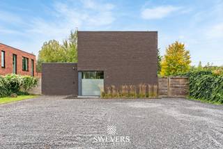 Voor meer info en foto’s, surf naar www.swevers.be –Deze instapklare open bebouwing aan de Wijerstraat 25 in Zonhoven combineert modern wooncomfort, energiezuinige voorzieningen en een ruim perceel van 8a 24ca met zuidwestelijke oriëntatie. De woning werd gebouwd in 2011, vernieuwd in 2023 en beschikt over een bewoonbare oppervlakte van 189 m². Op het gelijkvloers vindt u een inkomhal met gastentoilet en een lichtrijke leefruimte van 36 m². De open keuken van 18,4 m² met kookeiland sluit hier mooi op aan. Verder is er een bureau van 13,11 m² dat ook als derde slaapkamer kan dienen, evenals een praktische berging met wasvoorzieningen. De eerste verdieping telt twee volwaardige slaapkamers, waarvan één met dressing. De badkamer beschikt over een ligbad, dubbele wastafel en toilet. Ook op energetisch vlak scoort deze woning goed dankzij vloerverwarming op het gelijkvloers, gasradiatoren, twee airco-units, een warmtepompboiler uit 2023 en 16 zonnepanelen uit 2021 met een opgegeven jaaropbrengst van circa 6.000 kWh. Buiten geniet u van een ruime, zuidwestelijk gerichte tuin met terrasoverkapping en tuinhuis uit 2020. Ideaal om in alle rust van de namiddag- en avondzon te genieten. De ligging is eveneens gunstig, met openbaar vervoer op 280 meter, scholen op 2 km, winkels op 2,5 km en de snelweg op 3,8 km. Een comfortabele, energiezuinige gezinswoning met tal van mogelijkheden! Voor meer informatie, bel 011 255 155. Bron bewoonbare oppervlakte: EPC – verslag.