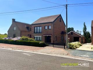 Ontdek deze ruime, open bebouwing gelegen op een zuidgericht perceel van 20a20ca met groene uitzichten over weilanden in een residentiële woonstraat nabij de dorpskern van Onze-Lieve-Vrouw-Lombeek. De vrijstaande gezinswoning beschikt over een bebouwde oppervlakte van maar liefst 344 m² en biedt tal van mogelijkheden voor wie op zoek is naar ruimte en een woning die nog volledig naar eigen smaak kan worden gemoderniseerd. Op de gelijkvloerse verdieping bevindt zich een inkomhal met traphal naar de eerste verdieping. De grote en lichtrijke leefruimte van 35 m² geniet van een aangenaam uitzicht op de tuin en sluit aan op de ingerichte keuken die toegang biedt tot de veranda en provisiekelder. Verder beschikt het gelijkvloers over een apart toilet, een chauffageruimte, enkele aanbouwen die dienen als berging, een inpandige garage met automatische poort die plaats biedt aan 1 wagen en een ruime oprit die zorgt voor extra parkeergelegenheid. Op de eerste verdieping geeft de nachthal toegang tot drie slaapkamers van 20m², 15m² en 11m² en een ingerichte badkamer met ligbad en toilet. De zolder biedt bovendien nog mogelijkheden om extra slaapkamers, een bureau- of hobbyruimte te creëren. De zuidwestgerichte tuin vormt een absolute troef en biedt een vrij uitzicht over de omliggende weilanden. De woning is verder uitgerust met centrale verwarming op mazout en dubbele beglazing. Kortom, een ruime woning met een solide basis, tal van praktische ruimtes en bijzonder veel potentieel. Interesse? Vraag nu meer informatie of maak een afspraak 054/69.68.67.