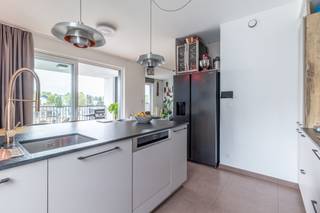 <p><strong>We Invest Sud-Luxembourg</strong> stelt u dit <strong>prachtige appartement van hoge kwaliteit</strong> voor, ideaal gelegen in het hart van <strong>Aarlen</strong>, op de 2e verdieping van een recent gebouw met lift (2019–2020 – Promotor Houyoux), vlak bij alle voorzieningen.</p>
<p>Bij binnenkomst wordt u verwelkomd in een <strong>ruime inkomhal met vestiaire</strong>, die leidt naar een lichtrijke leefruimte:<br />een <strong>Schmidt-keuken met centraal eiland</strong>, open naar een <strong>woonkamer met eiken parket</strong>, met directe toegang tot een <strong>overdekt terras van 8 m² op het zuiden</strong>.</p>
<p>Het slaapgedeelte omvat <strong>3 slaapkamers</strong>, waarvan één een <strong>ouderlijke suite met op maat gemaakte dressing en privébadkamer in massief hout</strong>. Een <strong>tweede badkamer met bad</strong>, een <strong>afzonderlijk toilet</strong>, en <strong>talrijke ingebouwde opbergmogelijkheden</strong> vervolledigen het geheel.</p>
<p>Daarnaast beschikt het pand over een <strong>privékelder</strong> en <strong>twee overdekte parkeerplaatsen</strong>.</p>
<p><strong>Technische kenmerken:</strong><br />EPC klasse <strong>A</strong>, verwarming op gas met gemeenschappelijke ketel, <strong>dubbele flux ventilatie</strong>, <strong>PVC driedubbele beglazing</strong>, <strong>elektrische rolluiken</strong>, maatmeubilair, privékelder.<br />Gebouw met <strong>lift</strong>, <strong>zonnepanelen</strong> en een <strong>regenwaterreservoir</strong>.</p>
<p><strong>Gemeenschappelijke kosten:</strong> ongeveer €200/maand – Syndicus: Serenity.</p>
<p>Een zeldzame kans die <strong>topligging</strong>, <strong>modern comfort</strong> en <strong>energiezuinigheid</strong> combineert!</p>
<p>Voor meer info of een bezoek: contacteer ons via +32 (0)63 33 00 69 – sud.luxembourg@weinvest.be</p>