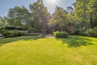 <p>Gelegen in een residentiële en groene woonomgeving bevindt deze villa zich op een royaal perceel van ca. 2.715 m², in een doodlopende straat. De fraai aangelegde tuin met vijverpartij geeft het geheel een aangenaam parkgevoel. Rust, ruimte en privacy zijn slechts enkele troeven van deze degelijke woning.<span></span></p>
<p>Bovendien is er weinig doorgaand verkeer, wat zorgt voor een veilige omgeving voor kinderen, wandelaars en fietsers. Het Zoerselbos, met ca. 400 hectare natuurgebied, bevindt zich op slechts 3 km afstand.</p>
<br /><span><strong>Indeling<br /><br /></strong></span>Inkomhal met gastentoilet voorzien van handenwasser, vestiaireruimte en toegang tot een polyvalente kamer van ca. 10 à 12 m², momenteel ingericht als hobbykamer. Verder bereikt u de leefruimte, die gekenmerkt wordt door royale volumes en veel natuurlijke lichtinval. Deze omvat momenteel een bureau met open haard en zicht op de tuin, een ruime zithoek met plafondhoogte tot in de nok en voorzien van een houtkachel, een afzonderlijk tv-salon, een eetkamer en een volledig ingerichte keuken (2000).
<p>Vanuit de keuken is er toegang tot de inpandige garage met aparte wasplaats. Via de garage bereikt u tevens de droge, geklimatiseerde wijnkelder.</p>
<span><strong>Verdieping<br /><br /></strong></span>De verdieping beschikt over twee met elkaar verbonden overlopen. De eerste, bereikbaar vanuit de inkomhal, geeft toegang tot drie slaapkamers. De tweede overloop, die eveneens rechtstreeks vanuit de leefruimte bereikbaar is, leidt naar de ruime hoofdslaapkamer met een grote ingemaakte kastenwand.
<p>De twee overlopen vloeien in elkaar over, maar kunnen desgewenst van elkaar worden gescheiden door middel van een deur.<span></span></p>
<p>Daarnaast omvat deze verdieping een ruime berging met Velux-dakraam, een badkamer met dubbele lavabo, ligbad en douche, en een afzonderlijk nachttoilet.<br /><br />Het creëren van een tweede badkamer is relatief eenvoudig realiseerbaar.</p>
<br /><span><strong>Tuin<br /></strong></span><br />Volledig omheinde tuin met een afsluiting van ca. 1,80 m hoog. De tuin beschikt over een grote vijverpartij, twee terrassen en een boomgaard.<br /><br /><span><strong>Bijzonderheden</strong></span>
<ul>
<li>Bevloering in natuursteen en parket</li>
<li>Verwarming deels elektrisch (radiatoren en accumulatoren) en deels op aardgas (vloerverwarming)</li>
<li>Houten en aluminium ramen met dubbele beglazing</li>
<li>Droge, geklimatiseerde wijnkelder</li>
<li>Voorzieningen voor aansluiting op de riolering zijn reeds aanwezig</li>
<li>EPC: label D – 326 kWh/m² jaar - <span><strong>EPC label C </strong></span>na plaatsen zonnepanelen (simulatie)</li>
<li>EPC-certificaat: UC 3890393</li>
<li>Elektriciteit wordt conform opgeleverd</li>
</ul>
<p><span><strong><br />Stedenbouwkundige inlichtingen</strong></span><span></span></p>
<p>Vg – Wg – Gvv – Gvkr – Gmo – Gworg</p>