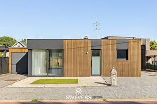 Voor meer info en foto’s, surf naar www.swevers.be – Deze recente, volledig gelijkvloerse bungalow aan de M. Scheperslaan 164 in Heusden-Zolder combineert comfortabel wonen, energiezuinigheid en een praktische indeling. De woning werd gebouwd in 2020, is instapklaar en onmiddellijk beschikbaar. Met een bewoonbare oppervlakte van 120 m² bevindt alles zich op één niveau. De ruime en lichtrijke living sluit aan op de keuken en biedt volop plaats voor een gezellige zit- en eethoek. Verder beschikt de woning over twee slaapkamers, een centraal gelegen badkamer, een praktische berging en twee toiletten. Ook buiten is er heel wat ruimte. Het perceel van 493 ca beschikt over een aangename tuin, een aparte garage, carport en tuinhuis. Zo zijn er voldoende parkeer- en opbergmogelijkheden. Op energetisch vlak scoort deze bungalow uitstekend met EPC-label A, een warmtepomp en maar liefst 19 zonnepanelen. Daarnaast zorgen airconditioning en elektrische rolluiken voor extra comfort. De ligging biedt een goede combinatie van rust en bereikbaarheid. School, openbaar vervoer, ontspanning en restaurants bevinden zich op korte afstand. Winkels en de snelweg zijn eveneens vlot bereikbaar. Een ideale woning voor wie gelijkvloers, modern en energiezuinig wil wonen met alle comfort binnen handbereik. Voor meer informatie, bel 011 255 155. Bron bewoonbare oppervlakte: EPC – verslag.