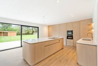 Deze villa gelegen in een rustige straat in residentiële verkaveling te Vlimmeren (Beerse) op perceel van 2.100 m². Het is een ideale woning voor wie op zoek is naar een energiezuinige woonst en nood heeft aan veel ruimte. Met een bewoonbare oppervlakte van maar liefst 643 m², 6 slaapkamers en 5 badkamers is dit een fantastische woning voor een groot gezin. Ze werd oorspronkelijk gebouwd in 1990, maar onderging in 2026 een complete renovatie. Zo werden er nieuwe ramen geplaatst, isolatie, een warmtepomp, alle ruimten voorzien van vloerverwarming, zonnepanelen, ventilatiesysteem, nieuwe keuken, badkamers, zeer veel inbouwkasten uitgevoerd in hoogwaardig schrijnwerk,.. Gunstig EPC label A (56 kWh/m²) !<br /><br />Deze villa omvat op het gelijkvloers een inkomhal met gastentoilet en links een bureau met inbouwkasten en vast bureaumeubel. Ruime woonkamer in L-vorm met veel plaats voor zit- en eethoek. Vanuit de woonkamer hebt u een open doorgang naar de leefkeuken. Deze is uiterst luxe afgewerkt met inbouwapparatuur van Miele en Liebherr (combi-oven, heteluchtoven, vaatwasser, koelkast, diepvriezer, inductiekookplaat met Bora afzuiging, Quooker kraan), hoogwaardig afgewerkt met werkblad in natuursteen en veel inbouwkasten in eikfineer. De leefkeuken biedt bovendien veel ruimte voor het plaatsen van een extra grote eettafel. De grote raampartij vanuit de keuken biedt onmiddellijke toegang tot het terras en de tuin. Verder op het gelijkvloers hebt u een praktische bijkeuken, een technische ruimte, een bergplaats voor vestaire met aparte douche en toilet en bovendien een afzonderlijke wasplaats met inbouwkasten. De garage bevindt zich eveneens aanpalende deze praktische bergplaatsen. <br /><br />De trap in hout brengt u tot de nachthal van de bovenverdieping. Hier treft u aan de straatzijde twee slaapkamers met élk een aanpalende dressingroom met inbouwkasten en vaste bureau's, alsook élk een eigen douchekamer.<br />Aan de achterkant treft u een masterbedroom met grote dressing, slaapkamer, apart toilet en badkamer voorzien van ligbad, douche en dubbele wastafel in op maat gemaakt meubel. Verder aan de achterkant nog 2 riante slaapkamers die beiden een douchekamer delen. Op de nachthal treft u nog een apart toilet. <br /><br />Een vaste trap die vertrekt vanuit de nachthal brengt u tot de bovenverdieping. Hier bevindt er zich nog een compleet ingerichte masterbedroom met dressing, slaapkamer en badkamer met ligbad, douche, toilet en dubbele wastafel. <br /><br />De tuin is zuidwestgericht en heeft een mooi terras dat grenst aan de leefkeuken. Achteraan op het perceel treft u een houten bijgebouw voorzien van een overdekt terras en een bergruimte, ideaal voor tuingereedschap etc. <br /><br />Bijzonderheden: <br />- Opportuniteit voor wie op zoek is naar ruimte en gunstig EPC label (A) - ideaal voor groot gezin ! <br />- Compleet gerenoveerd in 2026<br />- 6 slaapkamers en 5 badkamers<br />- verwarming dmv warmtepomp en vloerverwarming (ook koeling)<br />- zonnepanelen met batterij<br />- conforme elektrische keuring<br />- tuinberegening met putboring<br />- kabels aanwezig voor data/alarm/camera's<br />- Elektrische installatie voorzien van automaat voor laadstation; laadstation zelf nog te plaatsen<br />- ventilatie type D van Renson