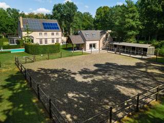 <p><span> </span></p><p><span>Cette villa majestueuse bénéficie d'un emplacement exceptionnel sur un terrain d'environ 5 000 m², jouxtant directement le golfe de Rinkven. </span></p><p><span>La propriété comprend une maison de campagne très spacieuse aux finitions luxueuses, une dépendance multifonctionnelle dotée d’un logement indépendant, une piscine à débordement chauffée et des installations équestres. La villa a été construite en 1999 et entièrement rénovée en 2020. Lors de cette rénovation, une attention particulière a été portée au confort de vie contemporain ; des matériaux haut de gamme ont été utilisés, avec des finitions particulièrement soignées. La combinaison d’un cadre verdoyant, à proximité immédiate du parcours de golf, et d’installations complètes pour l’élevage d’animaux fait de cette propriété un bien exceptionnel situé dans un cadre unique.</span></p><p><span> </span></p><p><span>Agencement</span><span>: vous entrez dans la villa par le vaste hall d’entrée doté d’un vestiaire, de toilettes pour invités et d’un escalier menant à l’étage. Depuis le hall d’entrée, vous accédez également à un bureau indépendant, idéal pour travailler au calme à domicile. Les vastes espaces de vie se composent d’une grande salle à manger, d’un salon convivial doté d’une cheminée à gaz à double face et d’un salon séparé. De grandes baies vitrées laissent entrer beaucoup de lumière naturelle et offrent une belle ouverture sur le jardin et la verdure environnante. Au cœur de l’espace de vie se trouve la luxueuse cuisine sur mesure. Celle-ci est équipée d’une gamme complète d’appareils encastrés haut de gamme, d’un îlot de cuisine spacieux et de plaques de cuisson intégrées de manière quasi invisible. À proximité se trouvent une buanderie pratique et un débarras frais. Depuis la maison, vous avez accès au double garage intégré. L’étage au-dessus du garage a été aménagé en un vaste espace de détente polyvalent et sert actuellement de salle de jeux et de fitness.</span></p><p><span> </span></p><p><span>Étage</span><span>: À l'étage, vous accédez au couloir central donnant accès à trois chambres spacieuses, dont l'une est actuellement aménagée en dressing. Ces chambres disposent d'une salle de bains séparée avec douche à l'italienne et meuble-lavabo sur mesure. La spacieuse suite</span><span>parentale</span><span> </span><span>comprend une grande chambre, un dressing privatif et une salle de bains luxueusement aménagée avec baignoire et grande douche à l'italienne.</span></p><p><span> </span></p><p><span>Grenier</span><span>: Un escalier fixe donne accès au vaste grenier. Celui-ci abrite actuellement les installations techniques et un débarras. La surface disponible offre en outre la possibilité d’aménager des chambres et salles de bains supplémentaires ou d’autres espaces polyvalents.</span></p><p><span> </span></p><p><span>Annexe multifonctionnelle</span><span>: Outre la maison principale, la propriété dispose d'une annexe à part entière, actuellement aménagée en salon de beauté et équipée d'installations d'habitation indépendantes. Le rez-de-chaussée comprend un hall d’entrée, un débarras ou un garage, une salle de bains avec douche à l’italienne, des toilettes et un meuble-lavabo, ainsi qu’un espace de vie avec une cuisine entièrement équipée comprenant un lave-vaisselle, un four et un four à micro-ondes «  ». Le débarras peut également servir de chambre au rez-de-chaussée si vous le souhaitez. À l’étage se trouvent deux chambres spacieuses et un débarras supplémentaire. Grâce à son agencement et à ses équipements indépendants, ce bâtiment se prête parfaitement à une utilisation en tant que maison d’hôtes, cabinet professionnel, bureau ou logement pour le personnel résidant sur place.</span></p><p><span> </span></p><p><span>Jardin et espaces extérieurs</span><span>: La villa est entourée d’un vaste jardin aménagé offrant beaucoup de calme et d’intimité. Depuis les pièces à vivre, vous profitez d’une vue magnifique sur le domaine privé et le parcours de golf de Rinkven adjacent. La piscine à débordement chauffée constitue un véritable point de mire dans le jardin. Conçue comme une piscine à débordement, elle dispose également d’une douche extérieure. De spacieuses terrasses ont été aménagées tout autour de la piscine.</span></p><p><span> </span></p><p><span>Équipements équestres</span><span>: pour les amateurs de chevaux, la propriété dispose de ses propres écuries, d'un pré et d'un paddock. Les environs offrent par ailleurs de magnifiques possibilités de randonnées à pied et à cheval. </span></p><p><span> </span></p><p><span>Particularités</span><span>: La villa est notamment équipée d’un chauffage au sol, de la climatisation, d’un système domotique, ainsi que d’un système d’alarme complet et d’une vidéosurveillance. Des panneaux solaires et des capteurs solaires contribuent au caractère économe en énergie de la propriété. La propriété bénéficie d’un label EPC B, très favorable. La combinaison d’une villa luxueusement rénovée, d’une annexe multifonctionnelle, d’installations équestres et d’une piscine chauffée sur un terrain d’environ 5 000 m² en fait un domaine particulièrement complet, situé dans un cadre magnifique à proximité du golf de Rinkven.</span></p><p><span> </span></p><p><span>Pour plus d’informations, veuillez contacter notre agence.</span></p>
