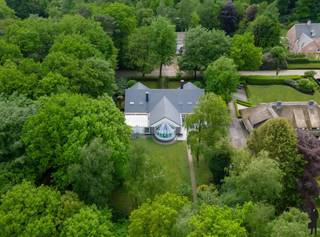 Op gegeerde locatie gelegen <strong>villa met binnenzwembad op ca. 2.489m² nabij het centrum van Kapellen! </strong><br /><br /><strong>Indeling:<br /></strong> <br /><strong>Gelijkvloerse verdieping:</strong><br />- Statige en open inkomhal op natuursteen met onbelemmerd zicht op het zwembad en aparte traphal met gastentoilet, handenwasser en vestiaire<br />- Ruim bemeten living op eiken parket met ingemaakte kasten en <strong>openhaard-cassette</strong><br />- Handig thuiskantoor of TV-kamer <br /><strong>- Nieuwe open keuken</strong> voorzien van toestellen met kookeiland<br />- Vanuit de leefruimte is er toegang naar het deels <strong>overdekte terras<br /></strong>- <strong>2 gelijkvloersslaapkamers</strong> met kamerhoge ramen, TV-aansluiting en grote badkamer ensuite voorzien van ligbad, 2 wastafels, bidet en toilet<br /><br />Het aangename en <strong>verwarmde binnenzwembad</strong> werd uitgewerkt in mozaëk, is voorzien van klimaatregeling en heeft een jetstream, vervolgens nog een finse<strong> sauna</strong> en een verzorgde kleedkamer/sanitair. <br />Door de <strong>enorme raampartijen</strong> rondom brengt men de privatieve tuin aangenaam dichtbij.<br /><br /><strong>Eerste verdieping:</strong> <br />- Via de traphal en een zeer ruime centrale tussenhal met zicht op het zwembad en de inkomhal. Heden werd hier een fitness voorzien maar er zijn tal van mogelijkheden. Zowel aan de linker- als aan de rechterzijde van het eigendom is er een <strong>enorme slaapkamer</strong>, 1 pas gerenoveerde badkamer met dubbele wastafel, inloopdouche, bad en toilet en een dressing. Het geheel ook hier boven op mooie eiken vloeren.<br /><br /><strong>Algemeen:</strong><br />- <span>Alle ruimtes in de gehele woning zijn royaal en beschikken over hoge plafonds</span><br />- Deze verzorgde villa met een groot volume heeft een <strong>dubbele, inpandige garage</strong> en nog een <strong>extra tuinkamer</strong><br />- Er zijn tal van mogelijkheden en heeft een <strong>prachtige tuin met diverse terrassen,</strong> mooie borders, oude bomen maar zeker geen inkijk<br />- Het eigendom is uitermate geschikt voor vrije beroepen