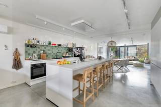 Een ruime, moderne en energiezuinige woning waar comfort en afwerking centraal staan! Deze prachtige woning, gebouwd in 2023, is gelegen in een rustige en aangename woonbuurt en is vlot bereikbaarheid.<br /><br />Met maar liefst 248m² bewoonbare oppervlakte biedt deze perfect afgewerkte woning uitzonderlijk veel ruimte. Het gelijkvloers vormt het hart van de woning, met een open woonkamer, stijlvolle keuken met bureauhoek, eetplaats, gezellige zithoek met zicht op de tuin.<br /><br />De woning beschikt over 5 kamers, waarvan 4 zeer ruime slaapkamers, voorzien van eigen lavabo. Eén slaapkamer geniet bovendien van een zuidgericht terras. Er zijn 2 volledig uitgeruste badkamers in de woning en een aparte wasplaats op het eerste verdiep. De vijfde kamer bevindt zich op het dakverdiep, samen met de technische ruimte.<br /><br />Ook op energetisch vlak biedt deze woning uitstekend comfort met een EPC-label A. Een warmtepomp staat in voor het sanitair warm water en de vloerverwarming op het gelijkvloers en in de badkamers. Daarnaast is de woning voorzien van airconditioning en een ventilatiesysteem D.<br /><br />Een bijkomende troef is het bijgebouw, voorzien van een derde badkamer en een polyvalente ruimte die perfect dienst kan doen als hobbyruimte, bureau of wellnessruimte.<br /><br />De zuidwestgerichte tuin biedt volop mogelijkheden om in alle rust van de buitenruimte te genieten.<br /><br />Een uitzonderlijk ruime, energiezuinige en volledig instapklare woning met een hoogwaardige afwerking, veel licht en tal van extra mogelijkheden.