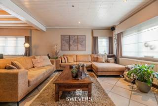 Voor meer info en foto’s, surf naar www.swevers.be – Op een ruim perceel van 865 m² in Heusden-Zolder bevindt zich deze open bebouwing met 182 m² bewoonbare oppervlakte. De woning uit 1954 biedt veel ruimte, een praktische indeling en een groene omgeving. Op het gelijkvloers vindt u een inkomhal, apart toilet, een royale woonkamer van 40,30 m² en een ruime keuken van 20,61 m² met aansluitende berging. Verder zijn er een badkamer en een ruime veranda met zicht op het achterliggende groen. De eerste verdieping telt drie slaapkamers van 20,80 m², 12,82 m² en 9,56 m². Daarnaast beschikt de woning over een kelder van 7,62 m² en een grote zolder, ideaal voor extra opslag. Het zuidwestelijk georiënteerde perceel biedt volop mogelijkheden om van de tuin te genieten. De zwemvijver en het bos achter de woning versterken het groene karakter. Een vrijstaande garage van 46 m² biedt plaats aan twee wagens en beschikt eveneens over een kelder. De kraan in de garage is aangesloten op een grondwaterput. Zonnepanelen en een batterij zijn eveneens aanwezig. Ook de ligging is praktisch, met openbaar vervoer op ca. 190 meter en winkels en restaurants op ongeveer 1 km. Scholen en ontspanningsmogelijkheden bevinden zich eveneens vlot bereikbaar. Voor meer informatie, bel 011 255 155. Bron bewoonbare oppervlakte: EPC – verslag.